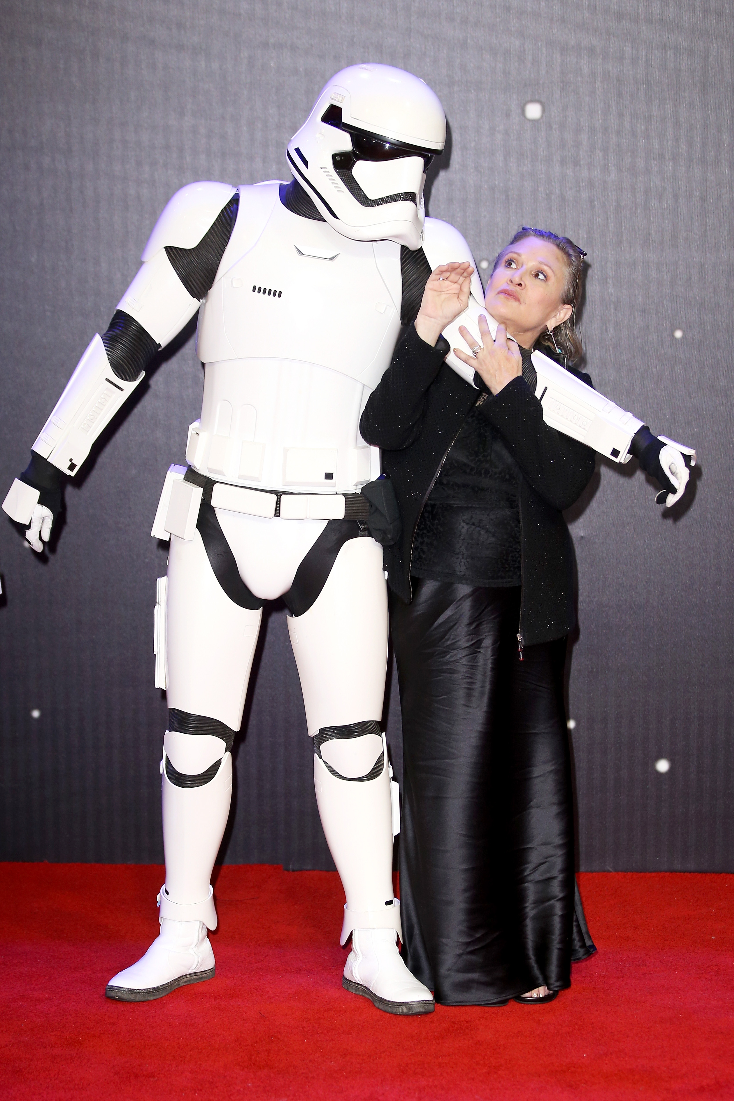 Carrie Fisher und ein Stormtrooper aus "Star Wars" bei der Europapremiere von "Star Wars: The Force Awakens" in London, 2015 | Quelle: Getty Images