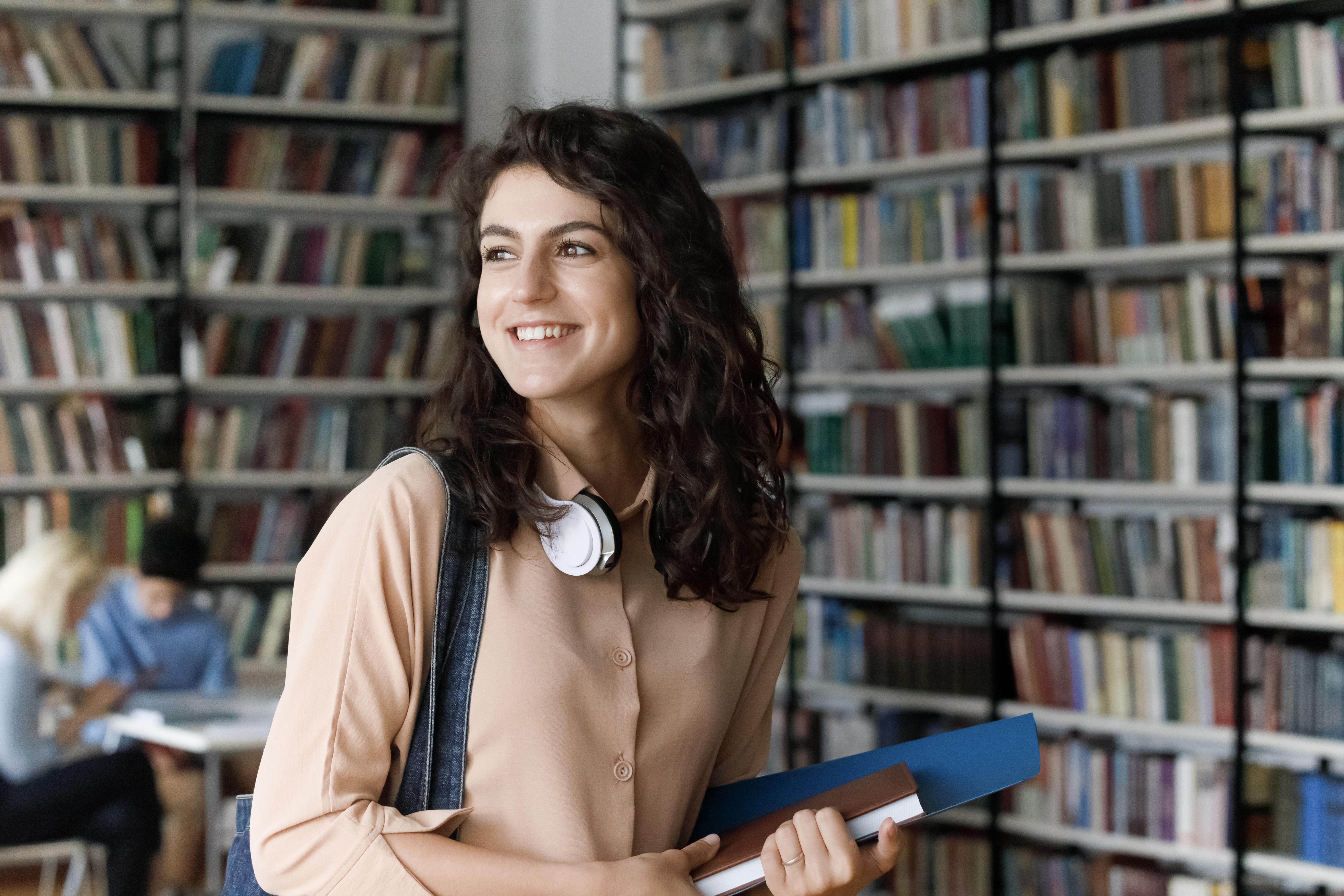 A happy girl standing in a library | Source: Shutterstock