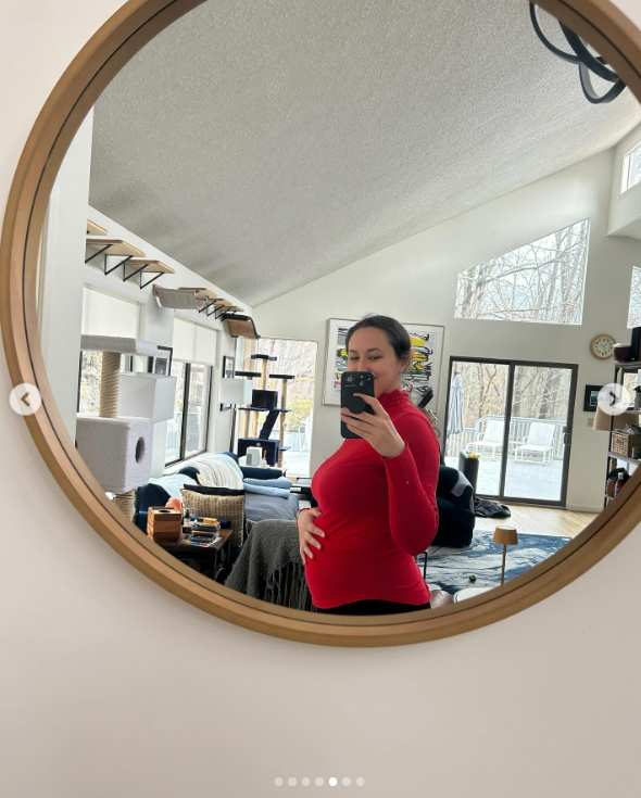 Emily Chase takes a mirror selfie showing her baby bump in the living room, posted in March 2024 | Source: Instagram/em_chases