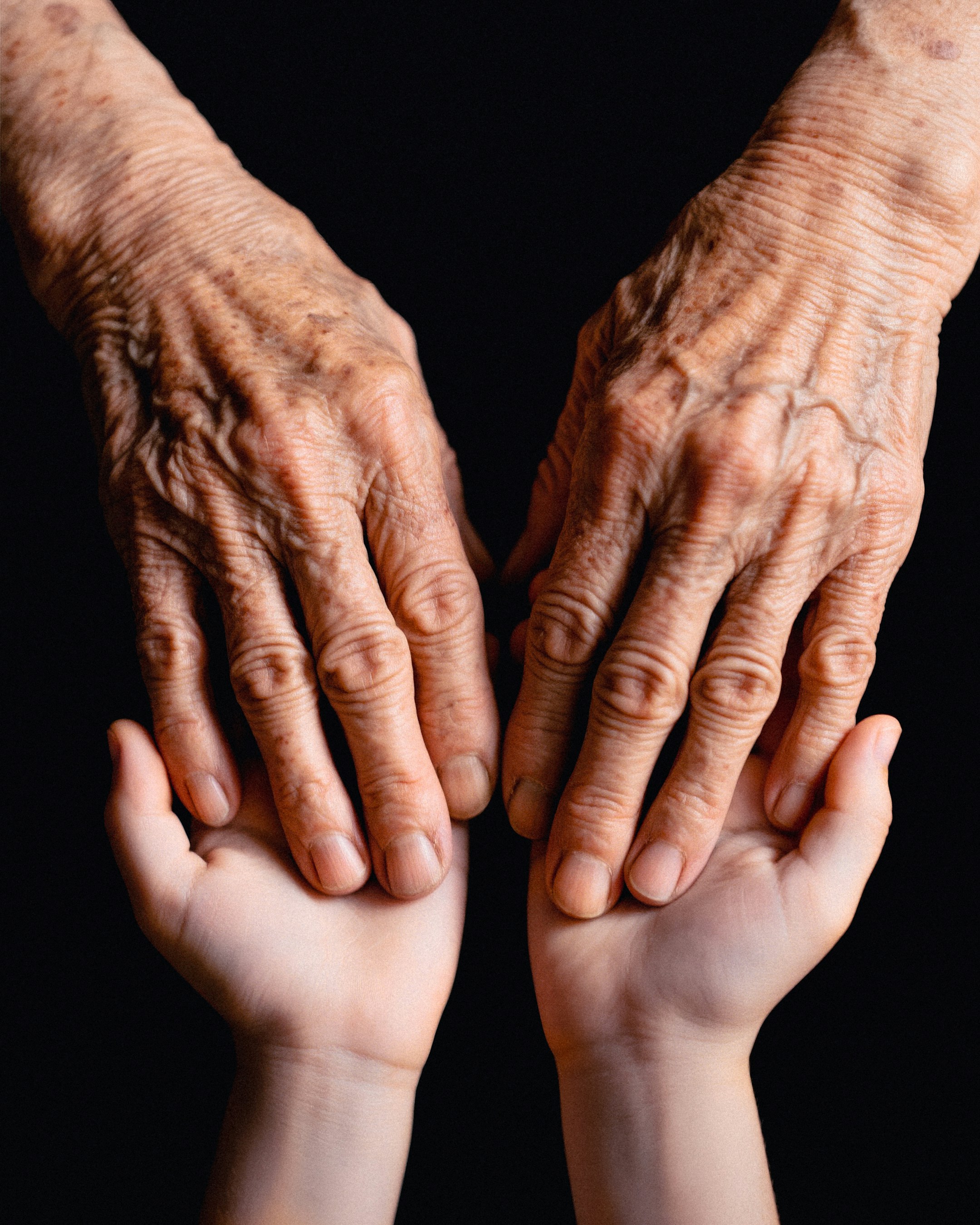 A young person and an older person's hands touching | Source: Unsplash