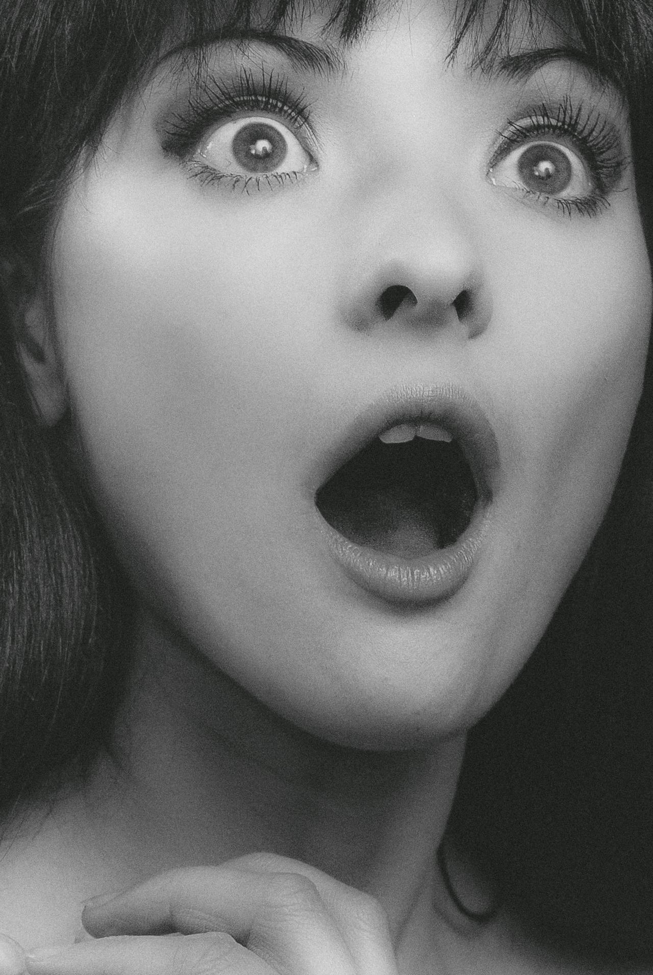 Grayscale shot of a shocked young woman | Source: Pexels