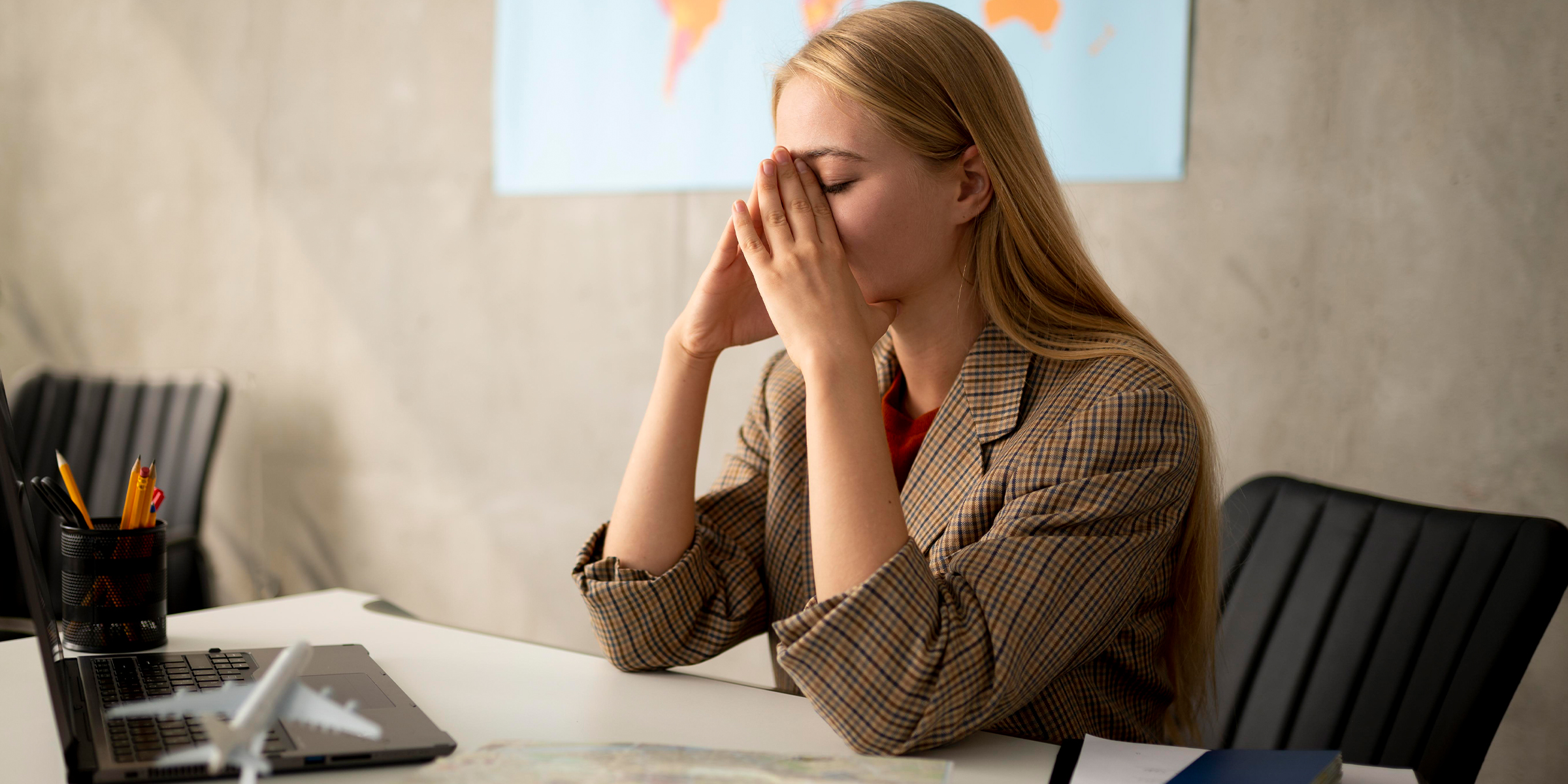 A frustrated woman sits at a desk | Source: Freepik