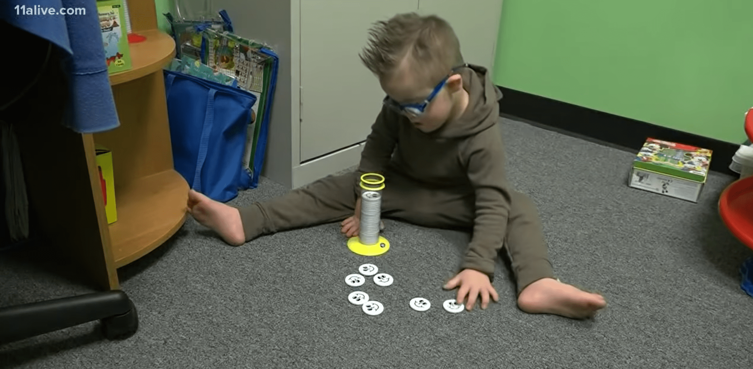 Special needs son playing with toys. | Photo: YouTube/11Alive