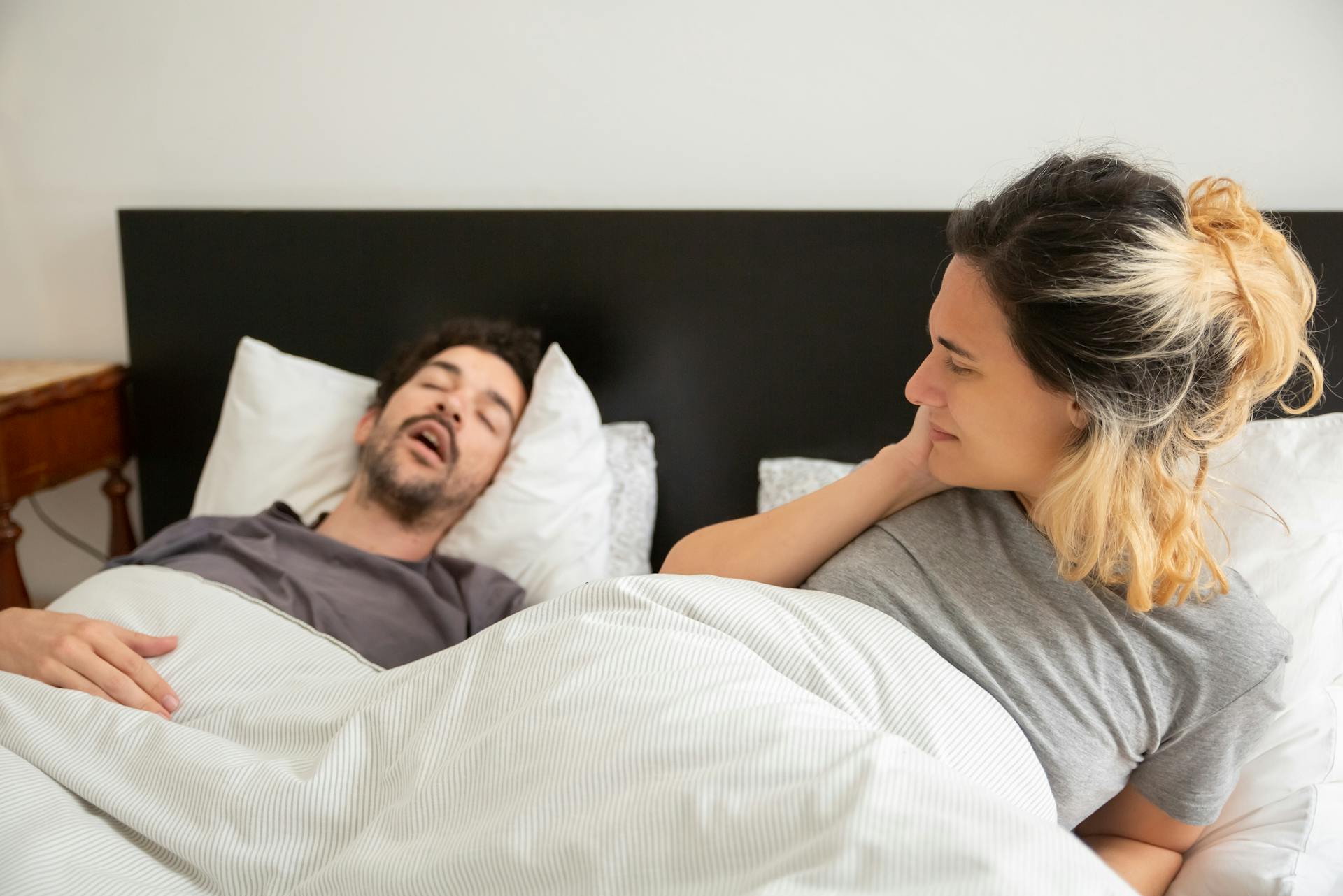 A woman looking at the man sleeping beside her | Source: Pexels