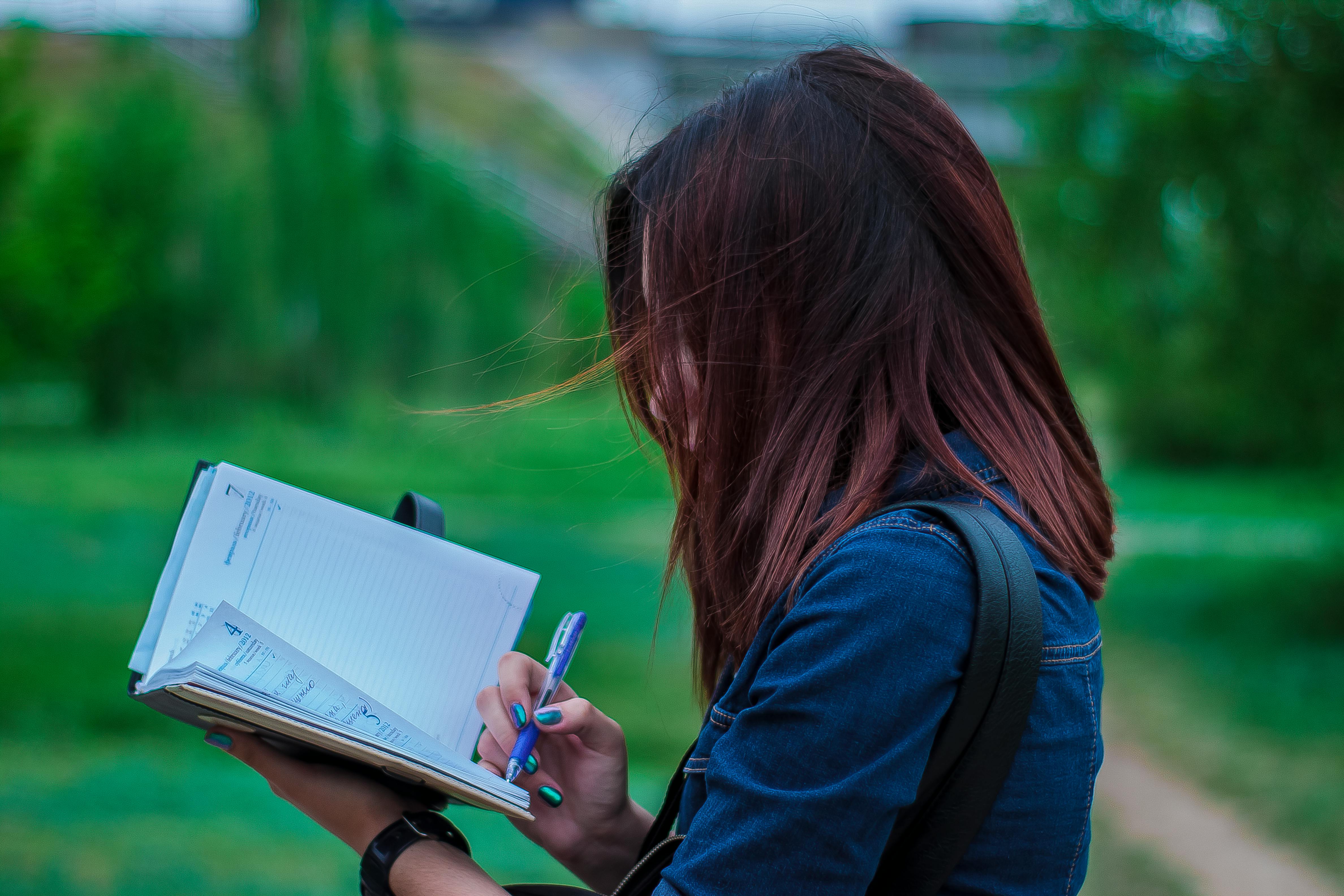 A woman writing hastily | Source: Pexels