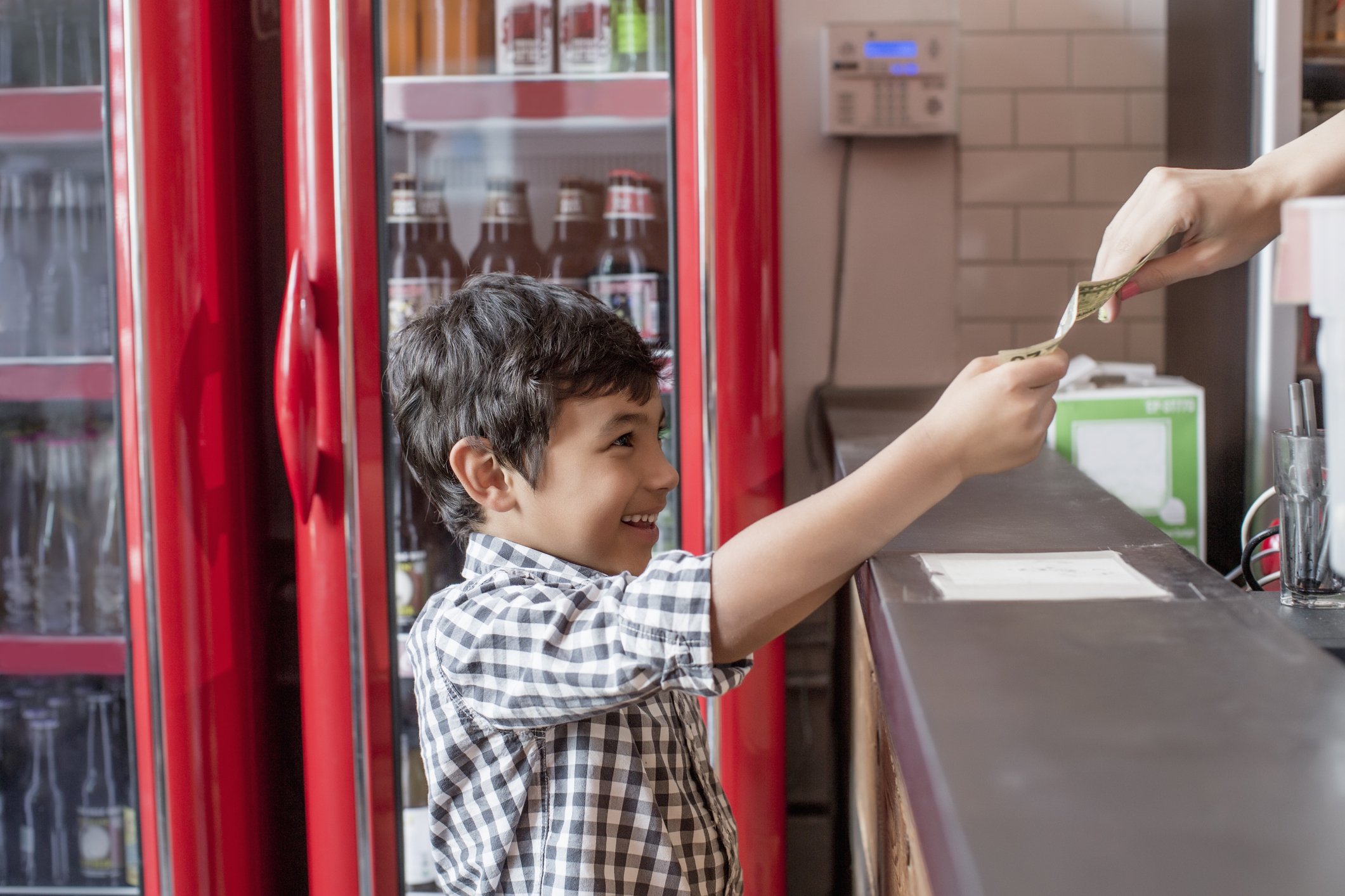 Photo of a young boy buying food in restaurant | Photo: Getty Images
