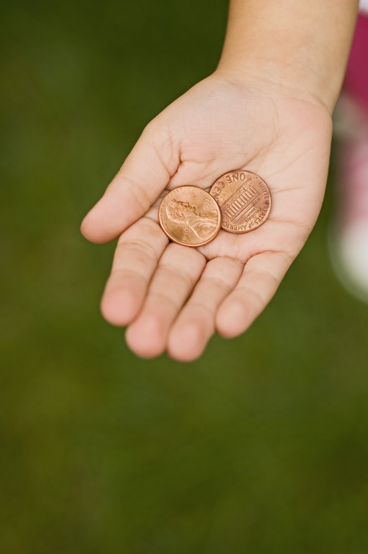 Hand holding pennies | Photo: Getty Images