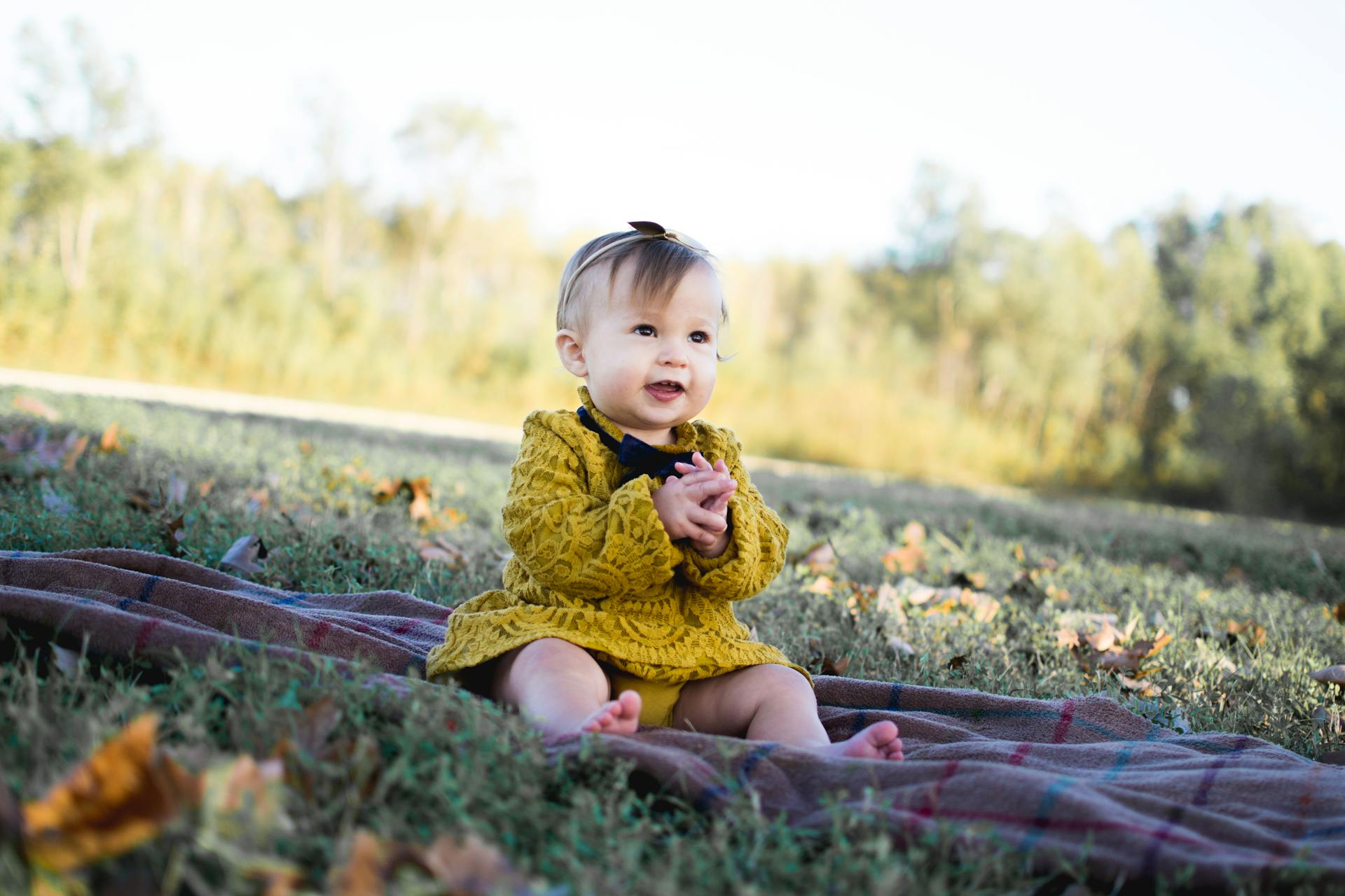 A baby girl sitting on a blanket outside | Source: Pexels