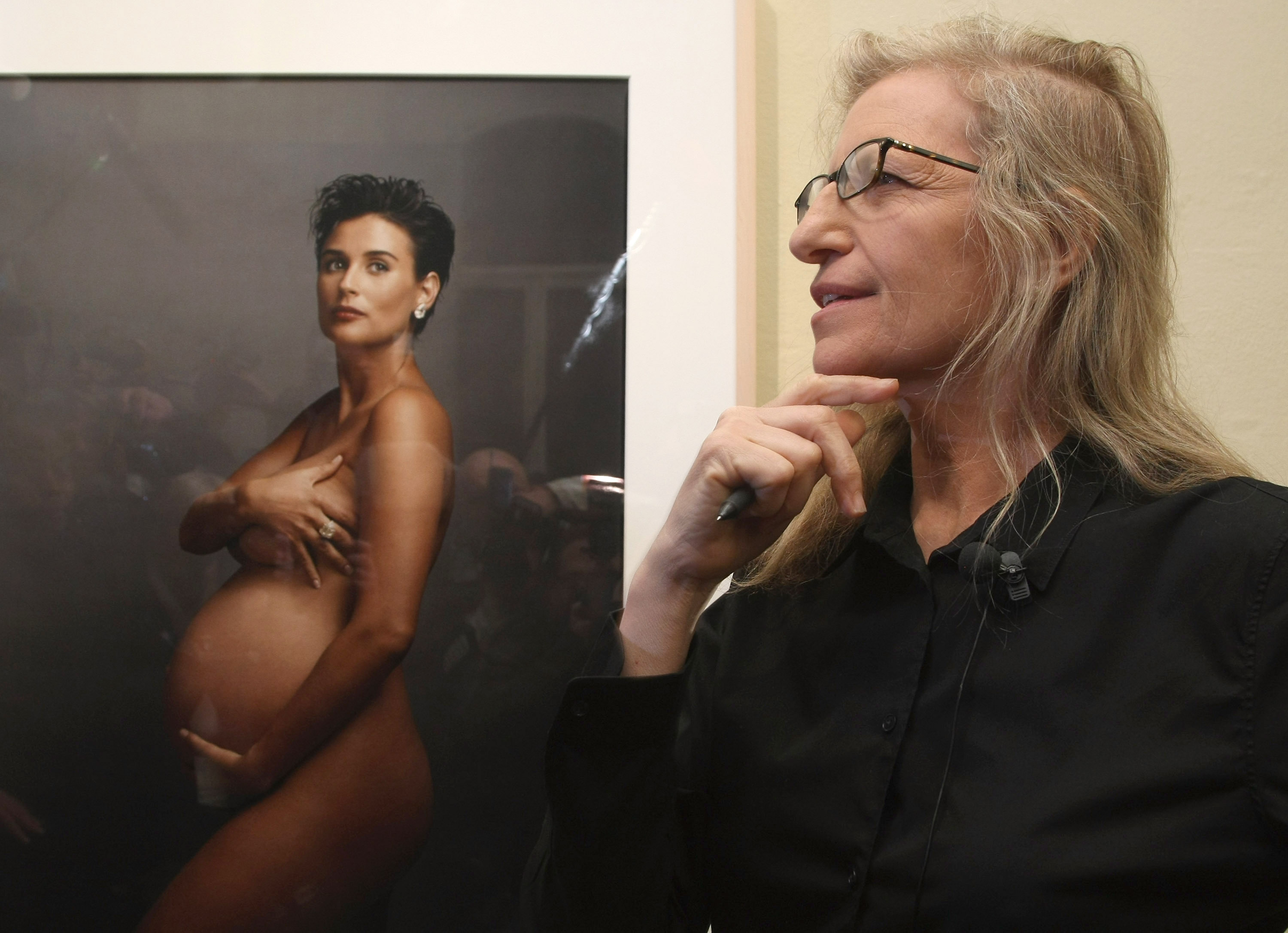 Annie Leibovitz stands in front of a portrait of pregnant actress Demi Moore during a walk-through of the exhibition "Annie Leibovitz - A Photographer's Life 1990-2005" at the C/O Gallery on February 20, 2009, in Berlin, Germany. | Source: Getty Images