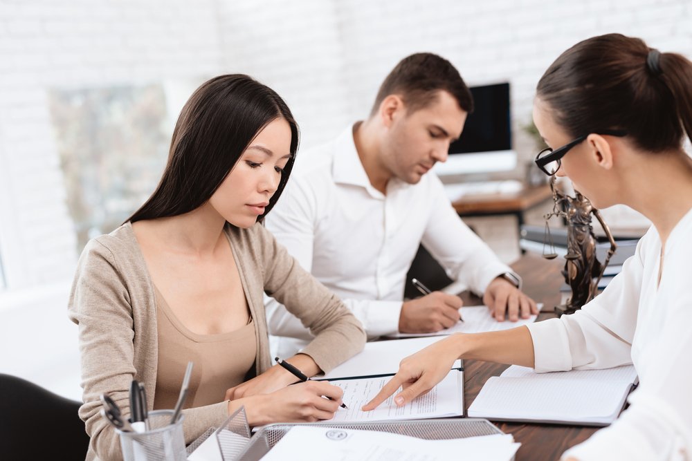 A couple signing their divorce proceedings at court. | Photo: Shutterstock.