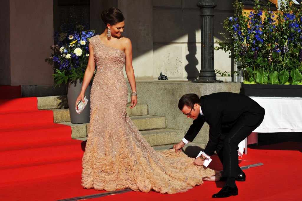 Princess Victoria is helped with her dress by fiance Daniel Westling during the Government Pre-Wedding Dinner for Crown Princess Victoria of Sweden and Daniel Westling at The Eric Ericson Hall on June 18, 2010 in Stockholm, Sweden | Photo: Getty Images 