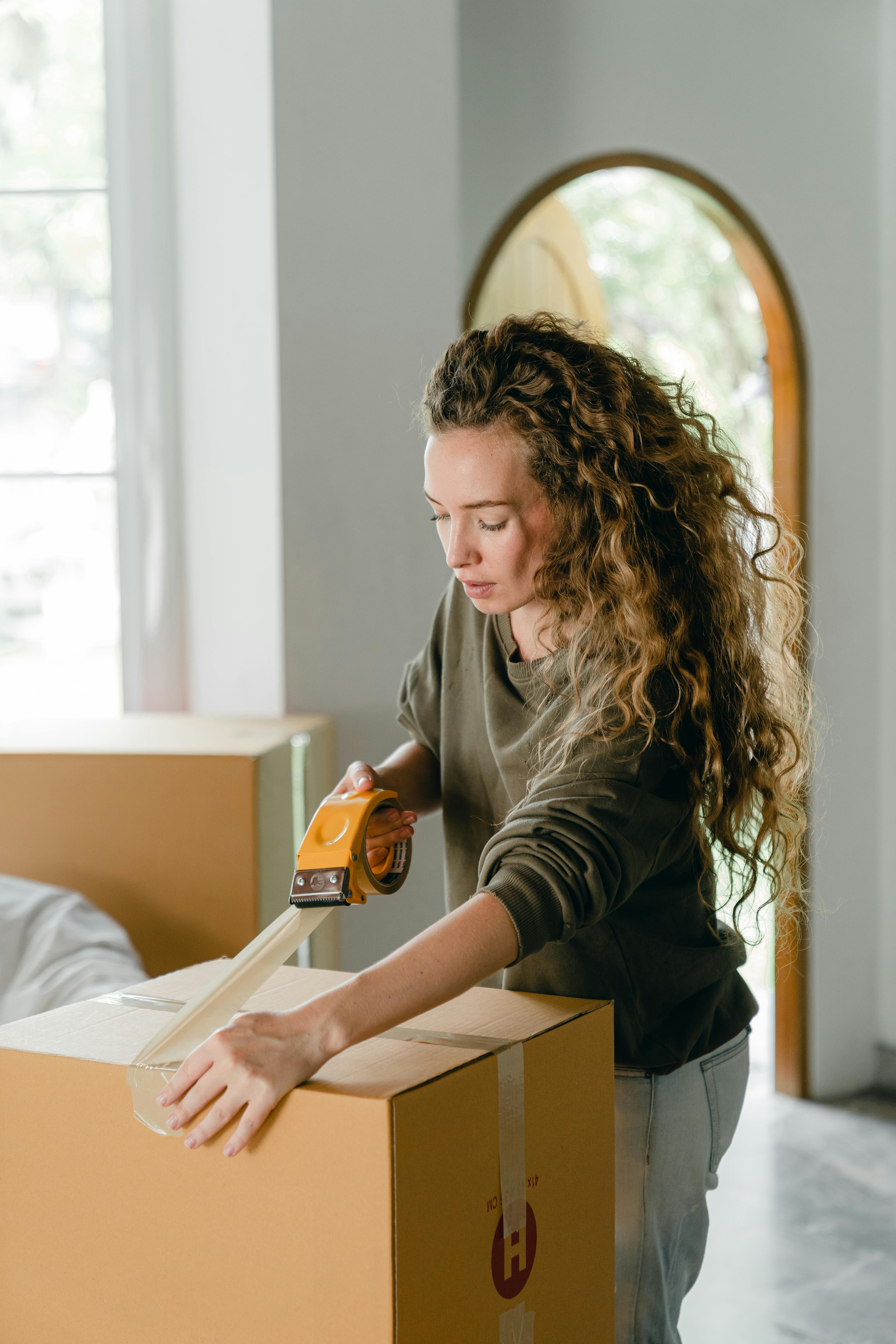 A young woman packing moving boxes | Source: Ketut Subiyanto on Pexels