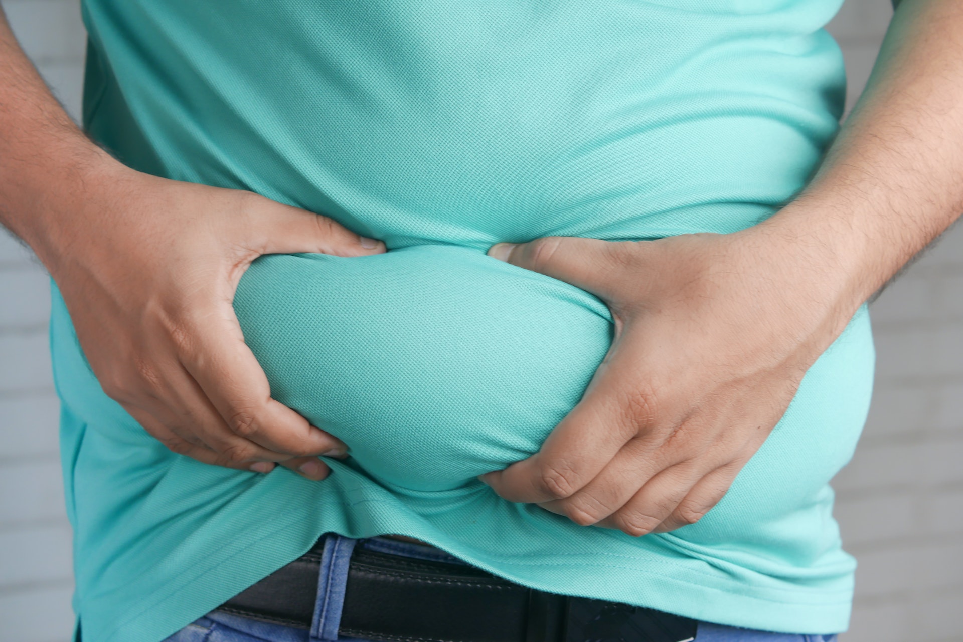 A person holding his belly fat | Source: Pexels
