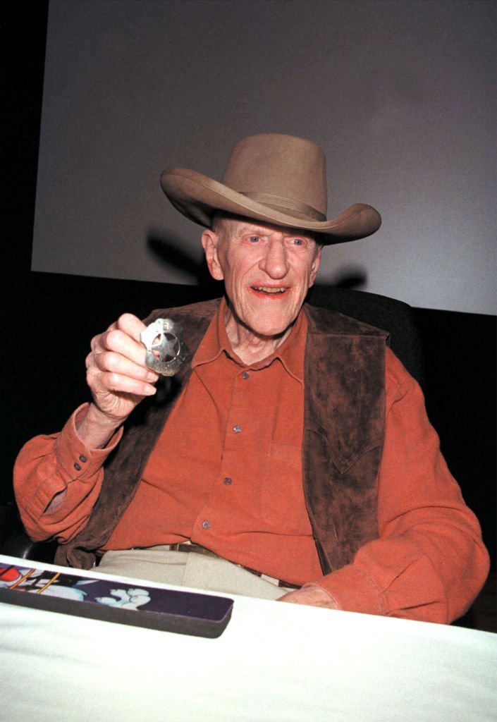 James Arness wears a cowboy hat and shows his sheriff's badge from the TV series, 'Gunsmoke,'  | Getty Images
