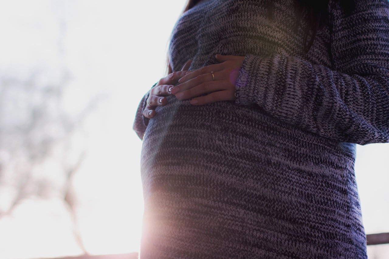Pregnant woman cradling her belly. | Source: Pexels/freestocks.org