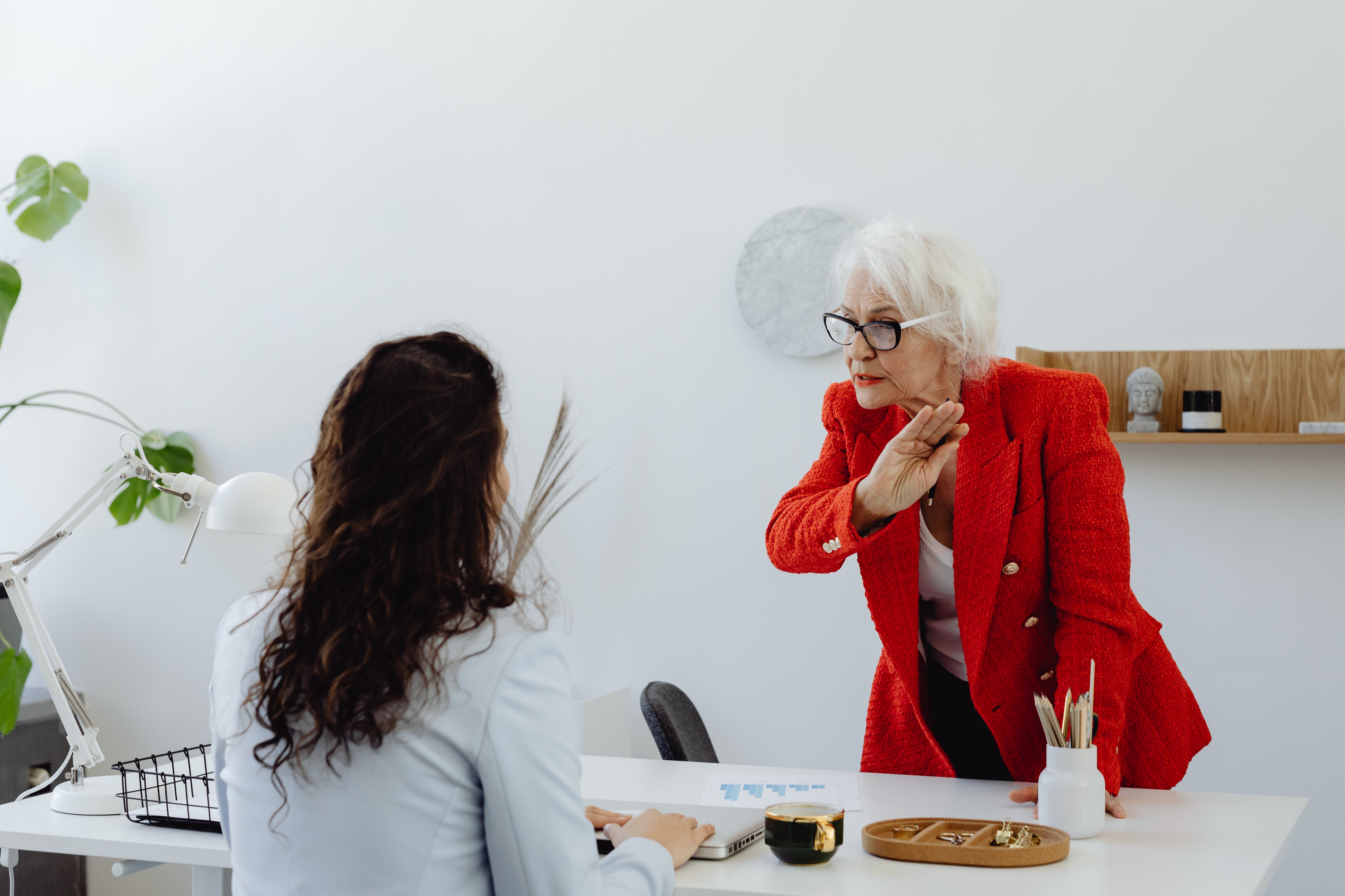 An older woman standing arguing with a younger one who's seated | Source: Pexels