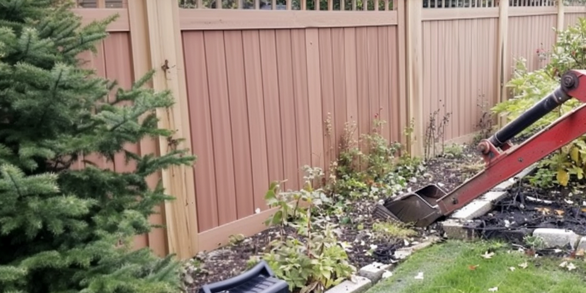A machine working on a garden close to a wooden fence | Source: Amomama