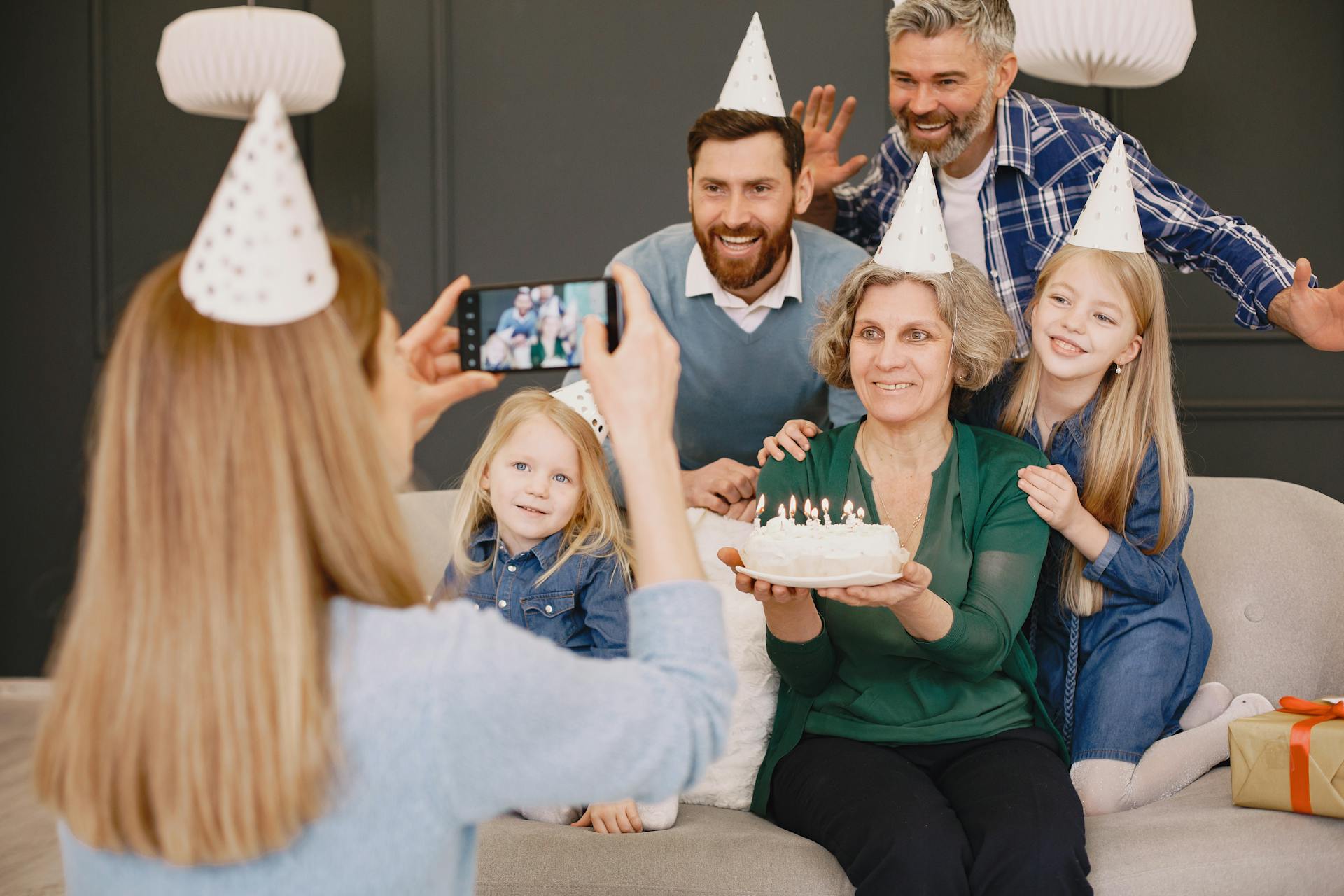 A woman clicking her family's picture at a birthday celebration | Source: Pexels