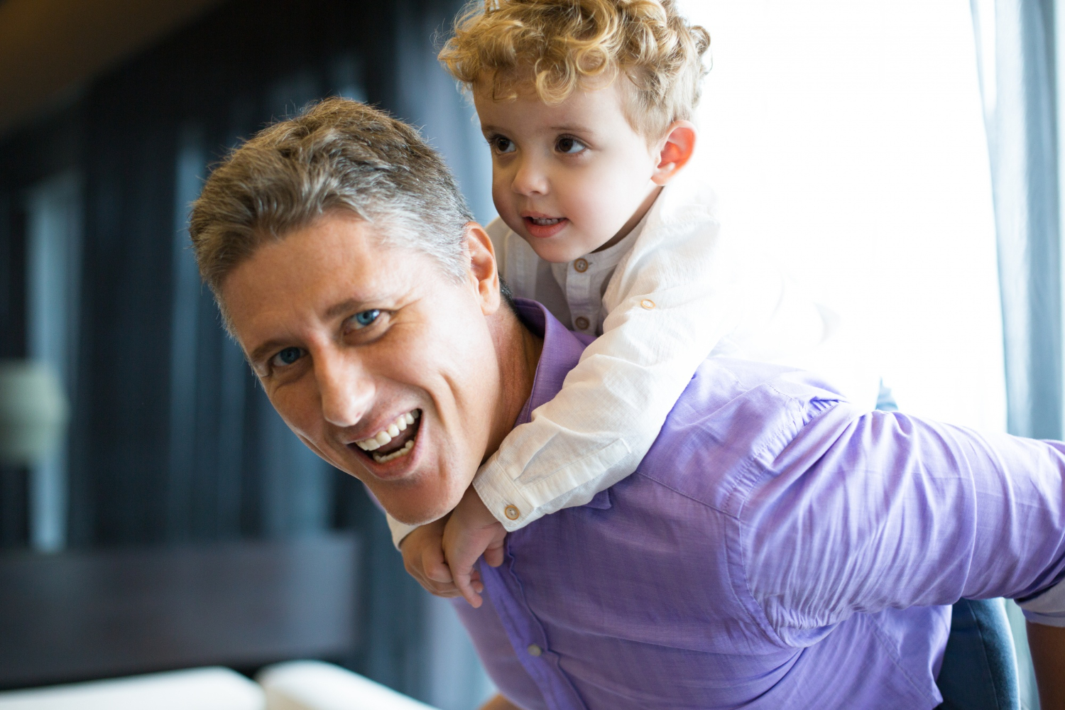 A man carrying a little boy on his back | Source: Freepik