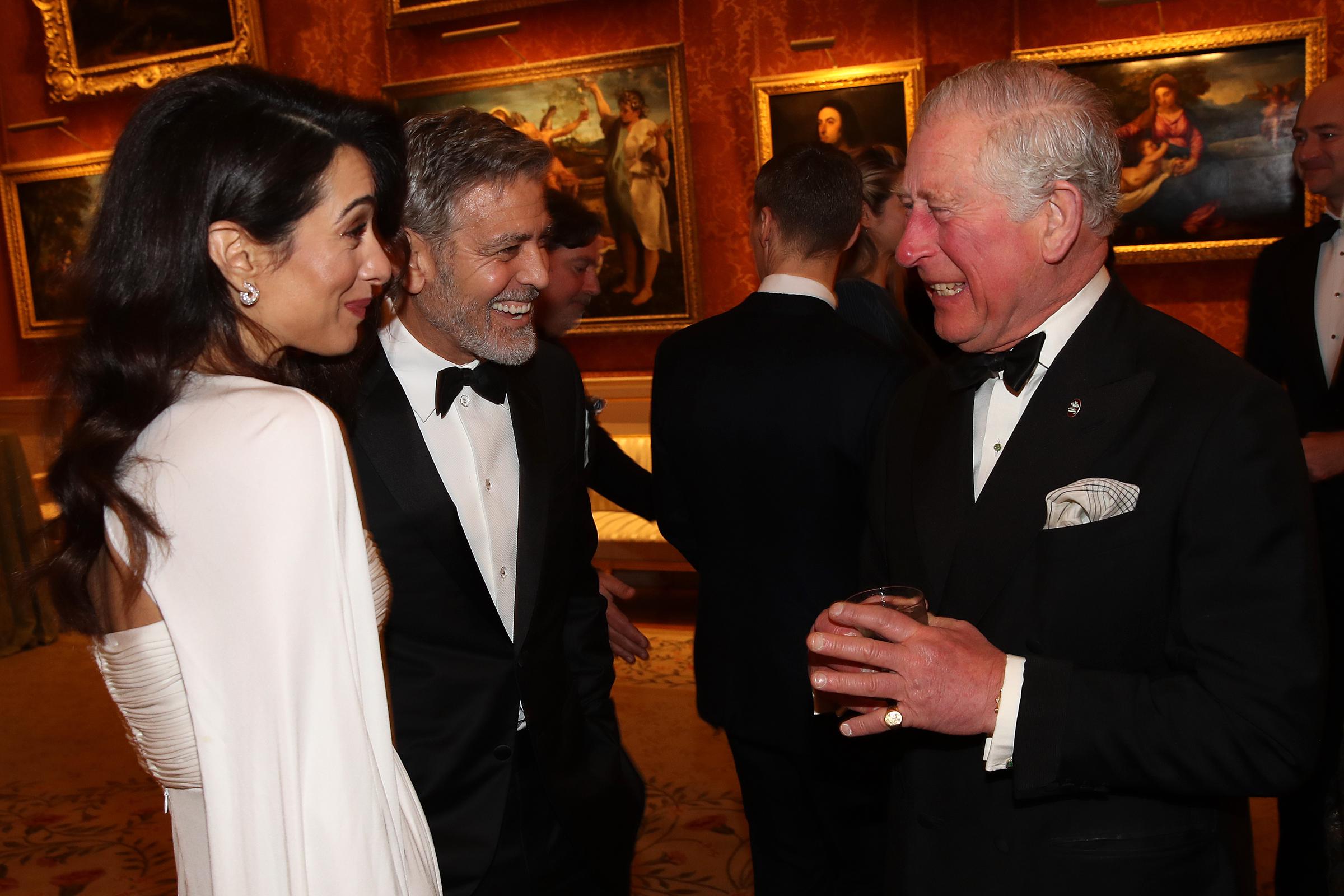 Amal and George Clooney speak to Prince Charles, Prince of Wales as they attend a dinner to celebrate The Prince's Trust at Buckingham Palace on March 12, 2019 | SOurce: Getty Images