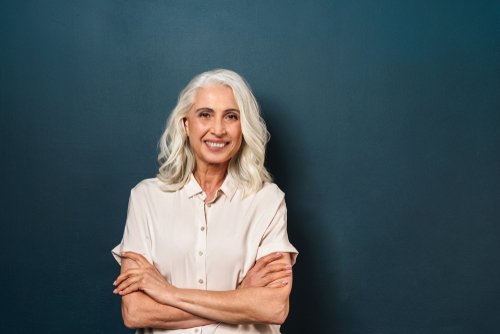 Une femme mûre avec les bras croisés et le sourire aux lèvres | Photo : Shutterstock.