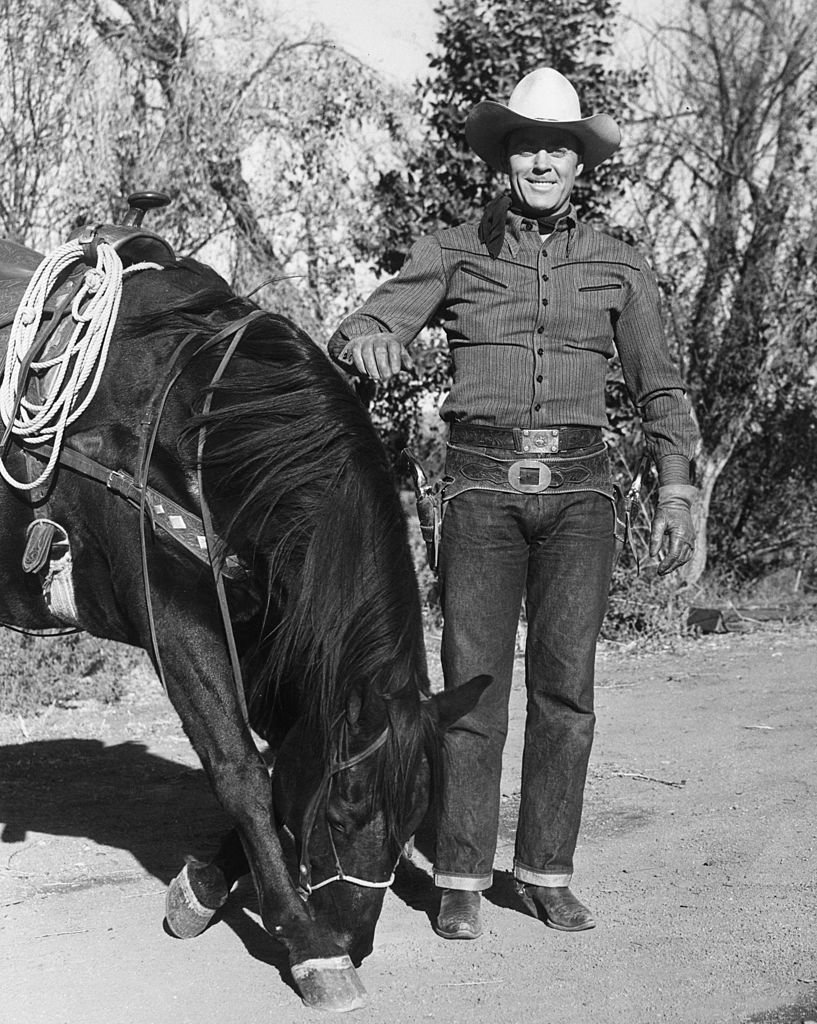 American film actor and former athlete Allan 'Rocky' Lane (1901 - 1973), in costume as a cowboy during a location shoot. 