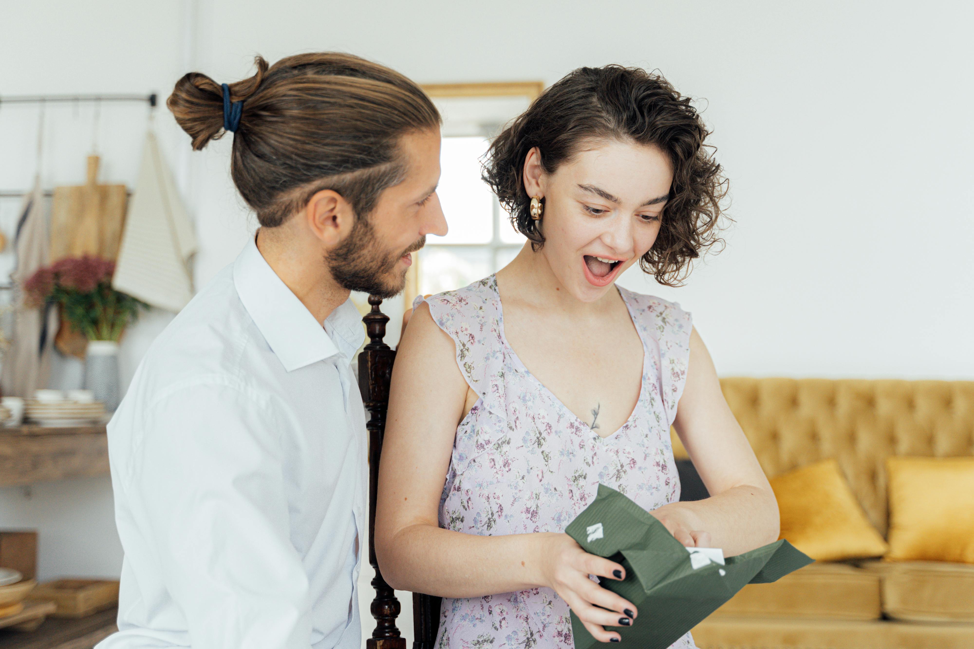 A woman reacting surprised to a gift from a man | Source: Pexels