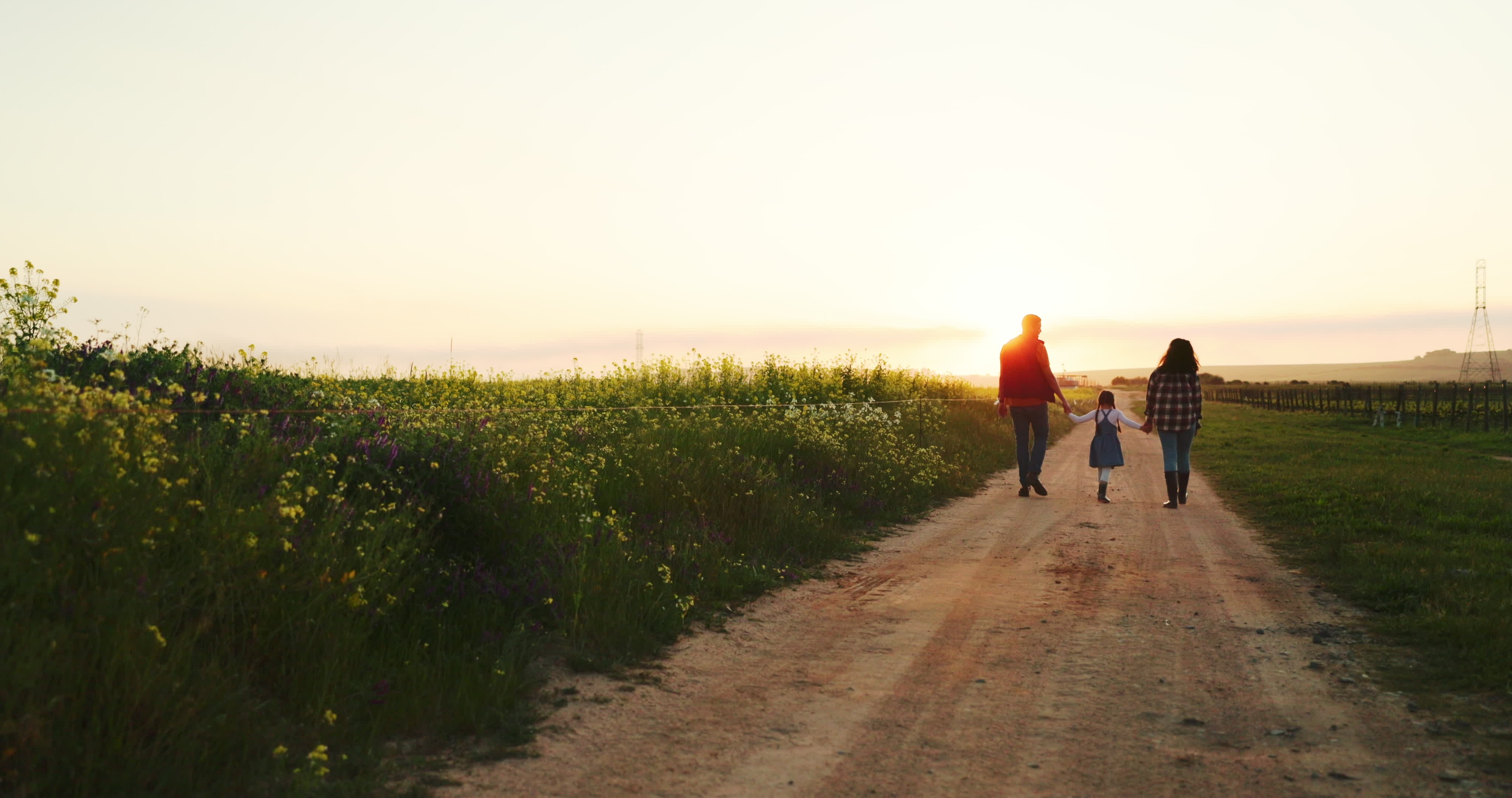 A family of three enjoying a walk on their farm | Source: Shutterstock