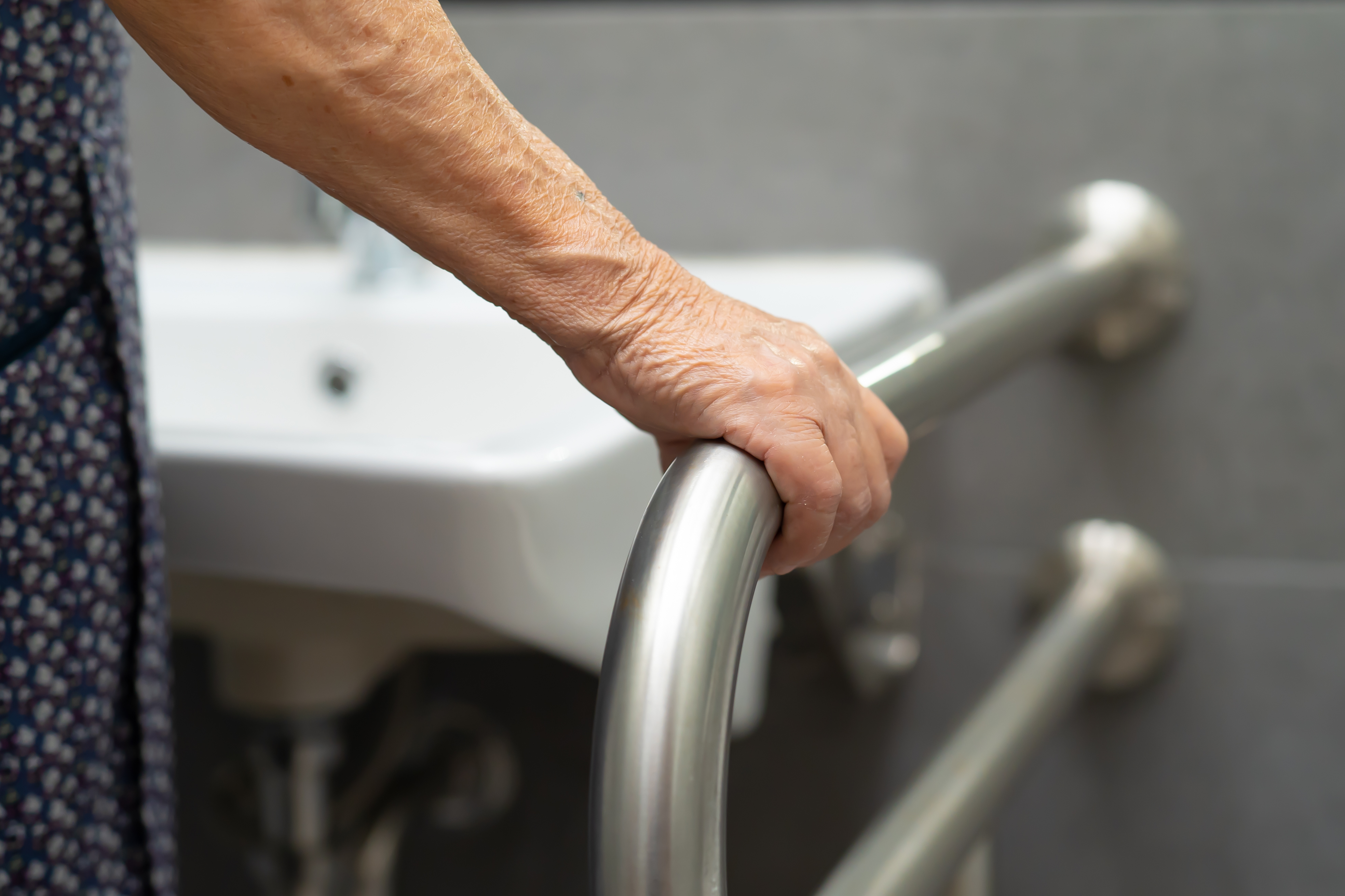 Woman holding a handrail in the restroom | Source: Shutterstock