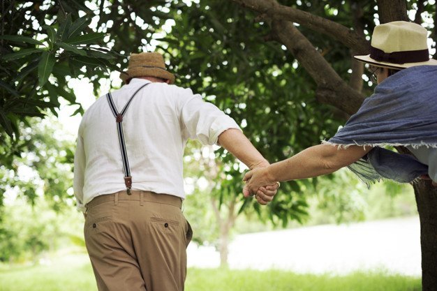 Un couple de seniors complices qui court dans un parc | Photo: Freepik