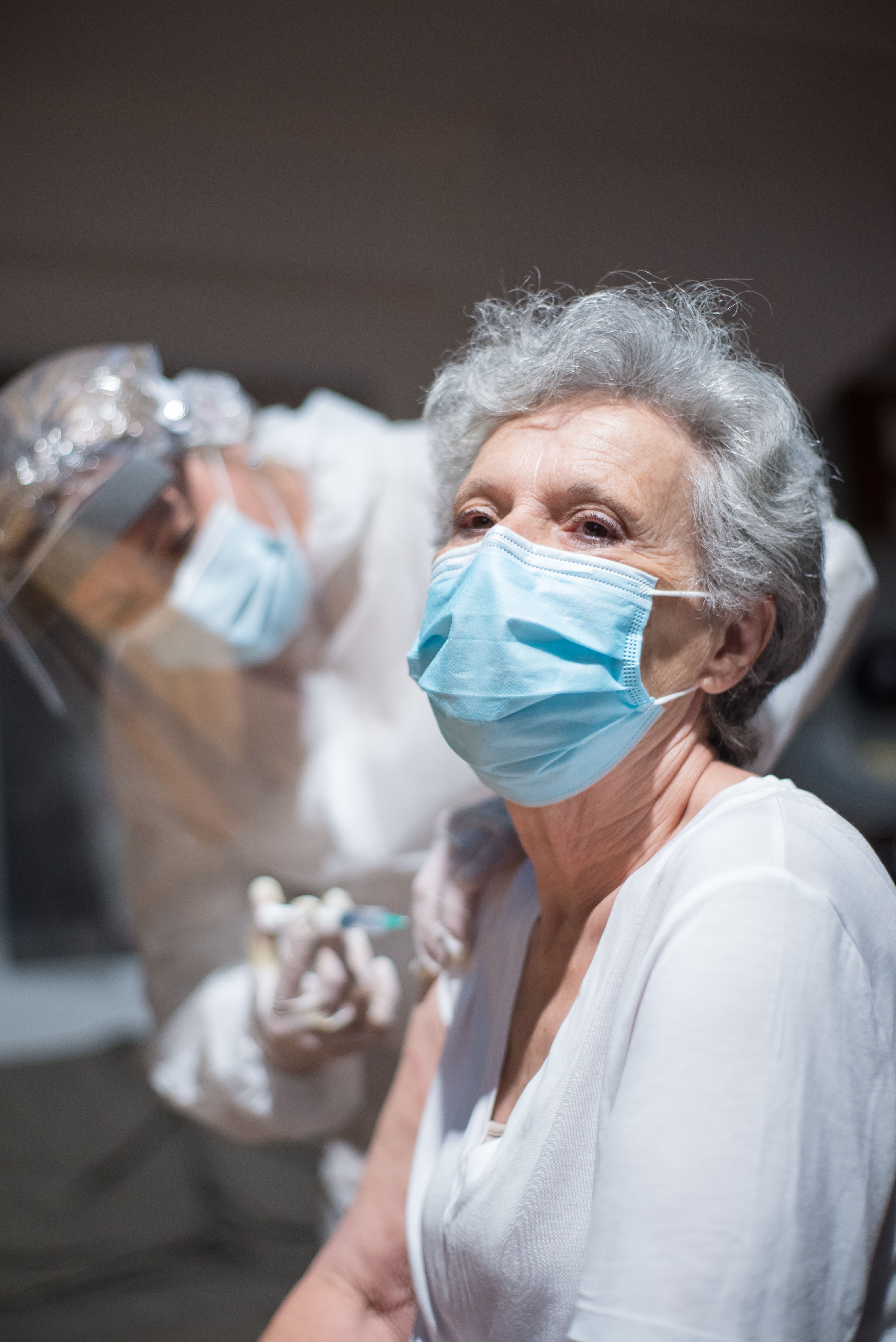 Woman with gray hair getting a vaccine shot | Source: Pexels