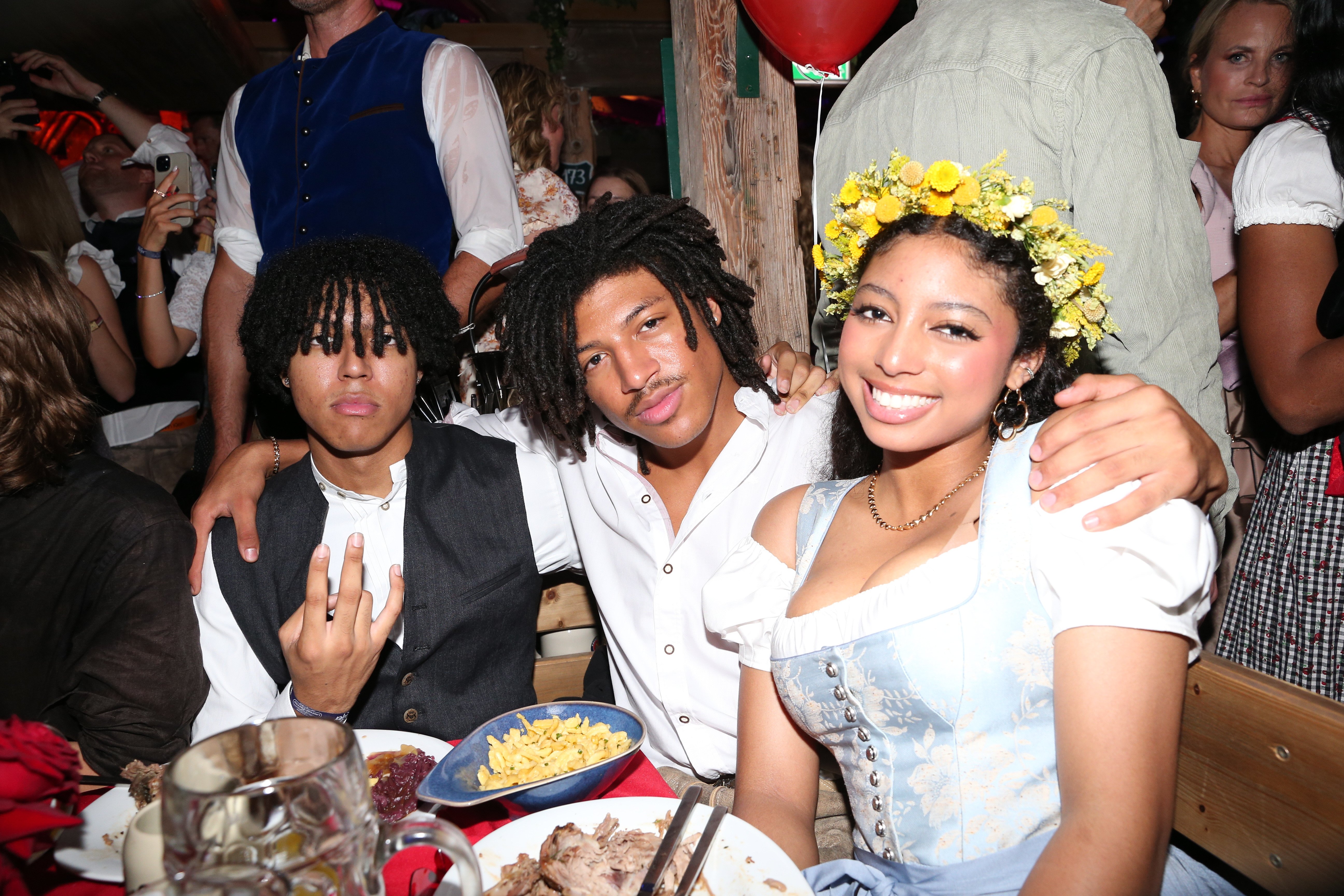 Amid the lively buzz of Oktoberfest in Munich, Johan, Henry, and Lou Samuel lean in close at a packed table. Their smiles, traditional flair, and shared laughter capture the spirited heart of the Wiesn celebration.