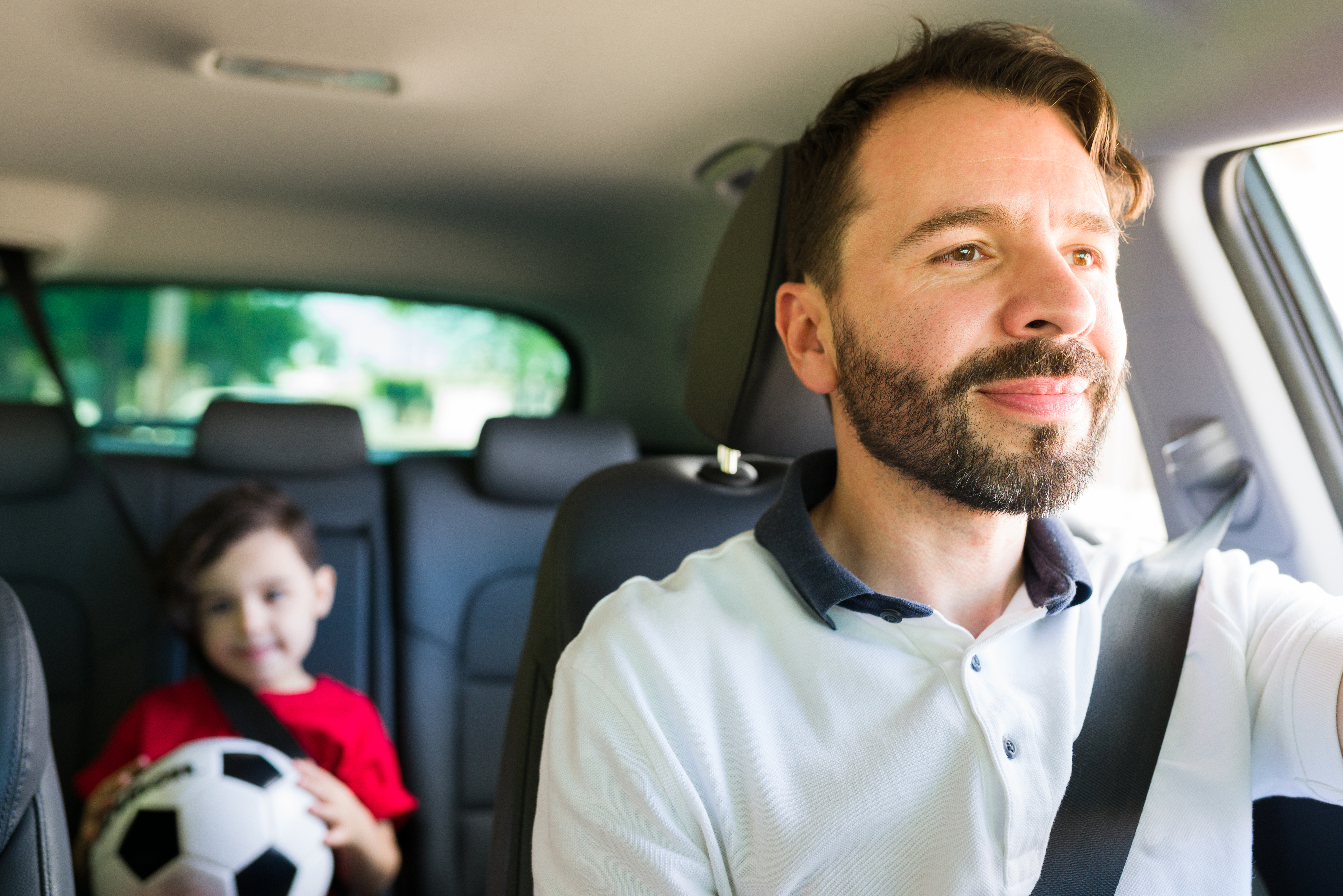 A man driving with a little boy in the back seat | Source: Shutterstock