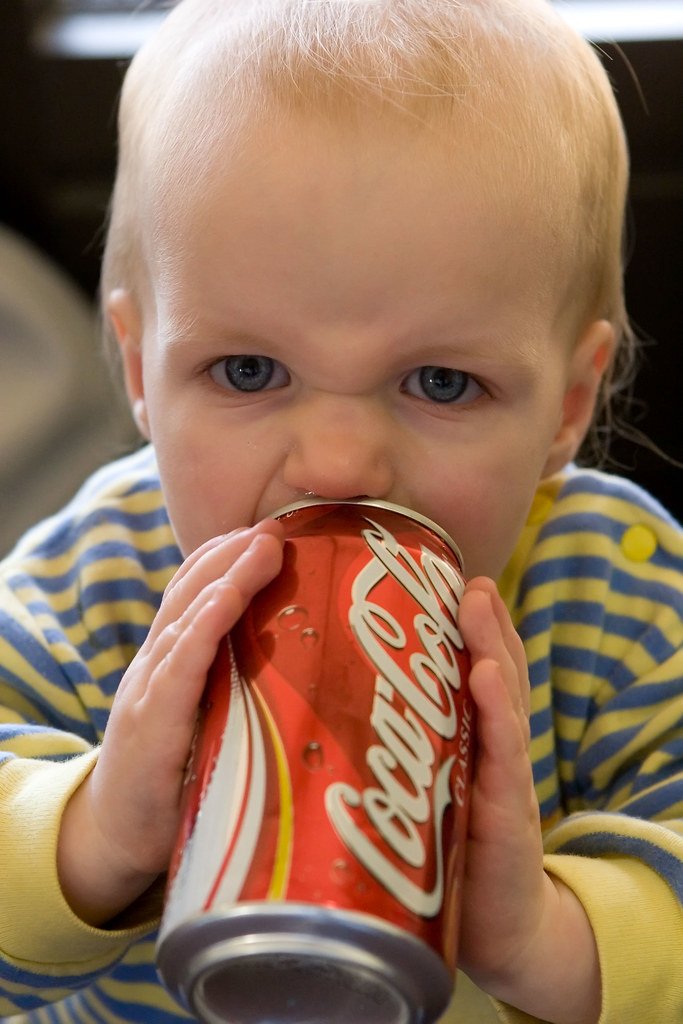 Bebé bebiendo Coka-Cola de lata.| Imagen: Flickr