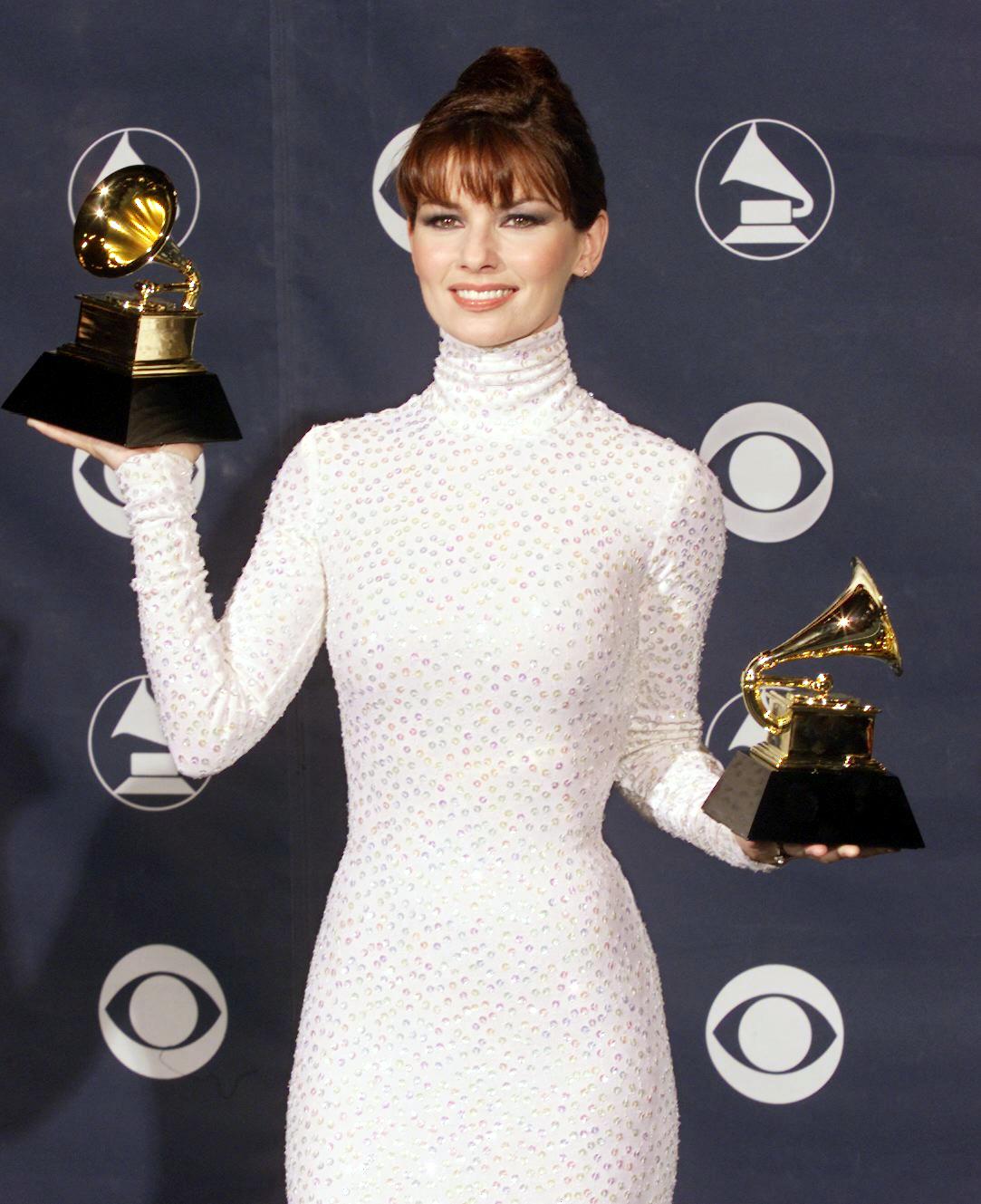 Shania Twain holding two Grammy Awards for Best Country Song and Best Female Country Vocal in LA, 1999 | Photo: Getty Images 
