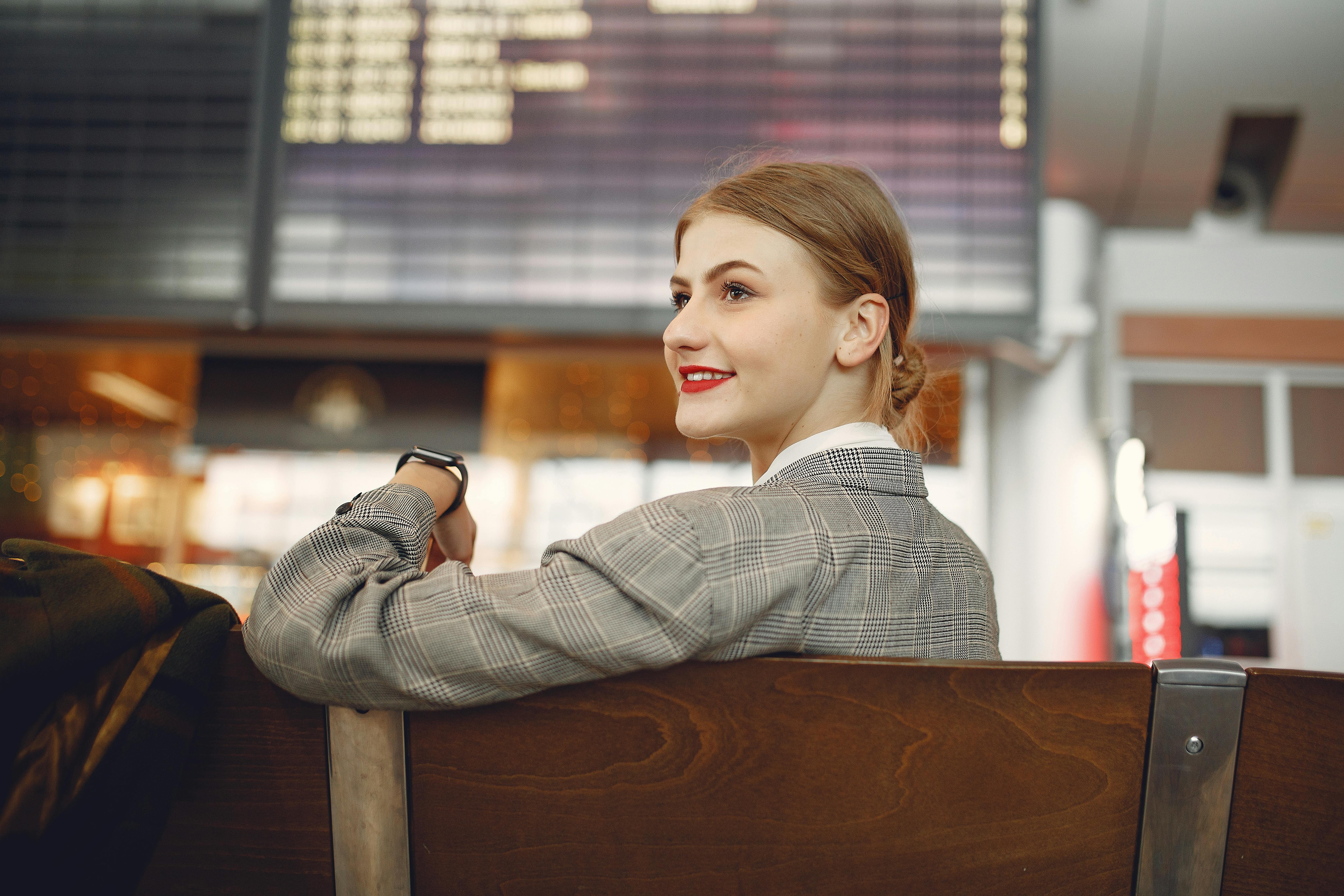 A happy woman seated at the airport | Source: Pexels