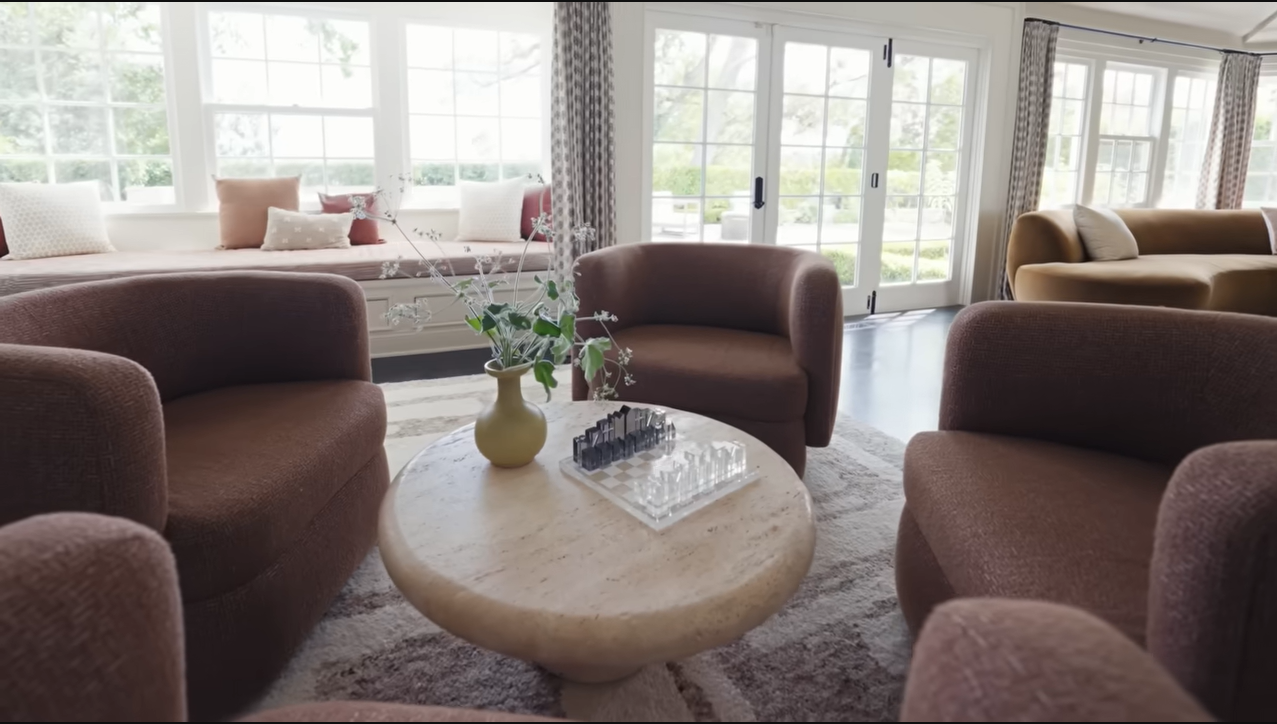 A thick stone coffee table displays a custom glass chess set right in the middle of the main conversational circle. | Source: YouTube/@Archdigest