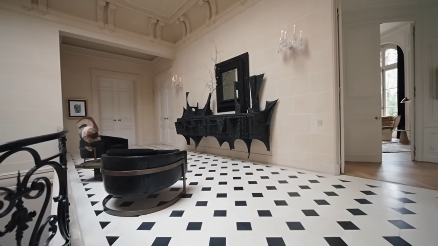The chic second-floor landing is styled with plush black lounge chairs and a sharp, brutalist black console table. | Source: YouTube/@Archdigest
