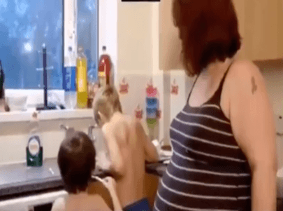 Sonia O'Lachlan et 2 de ses enfants se lavant dans l'évier | Photo : YouTube/ Nouvelles en direct maintenant