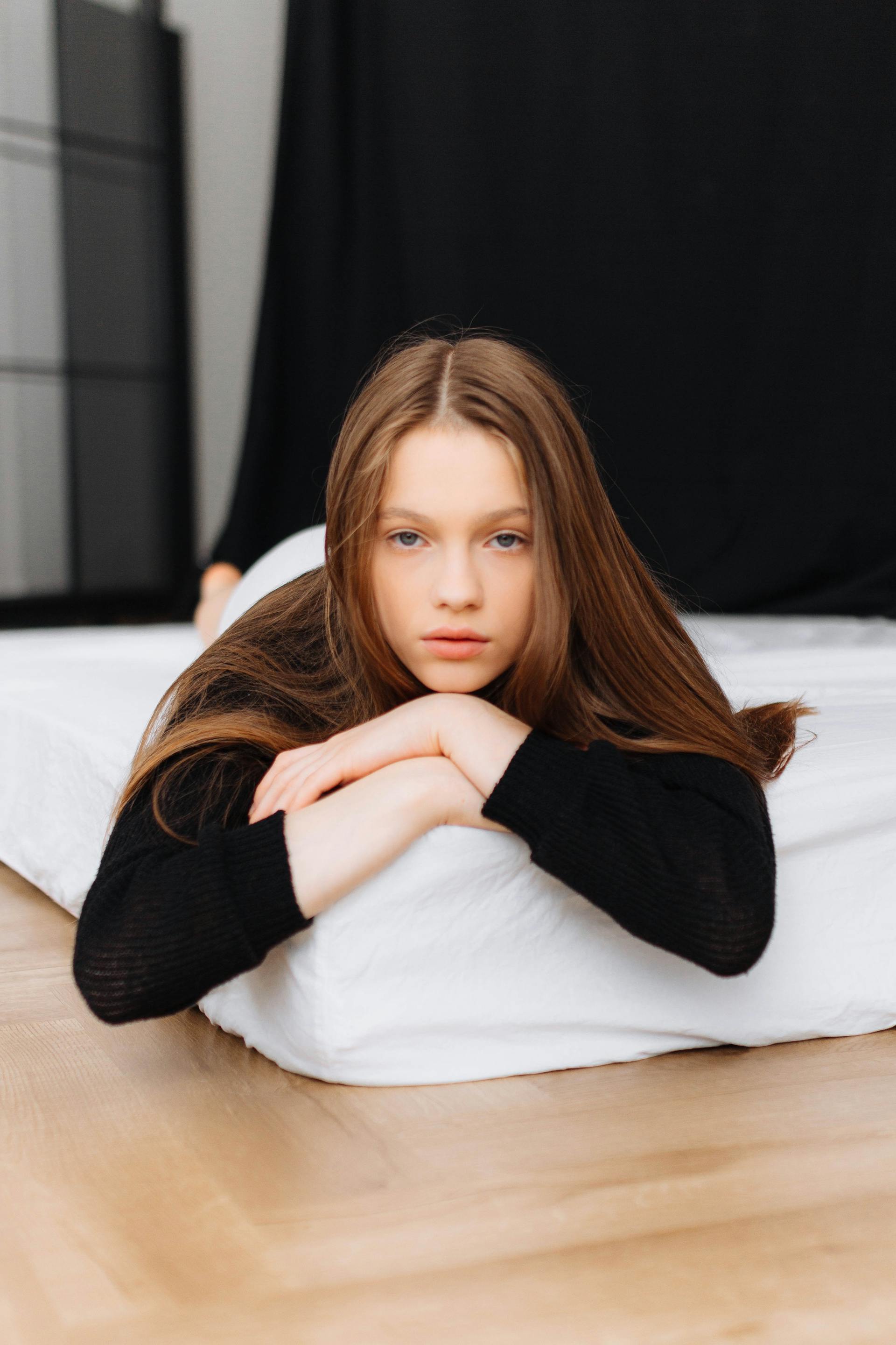 An upset teen girl lying down | Source: Pexels