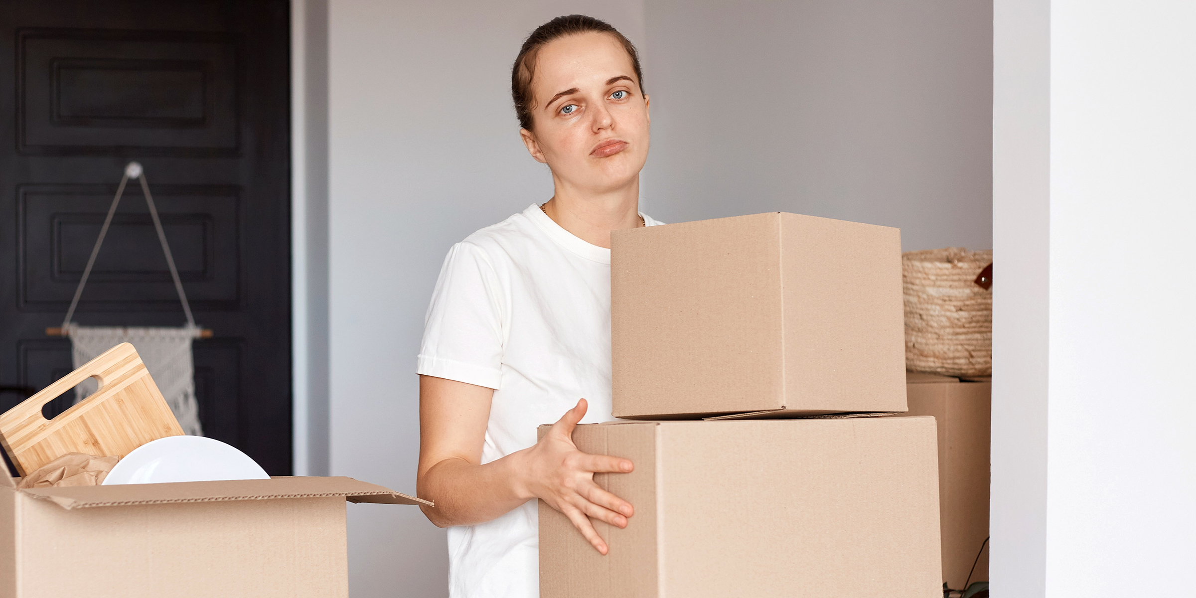 A sad woman holding boxes | Source: Shutterstock