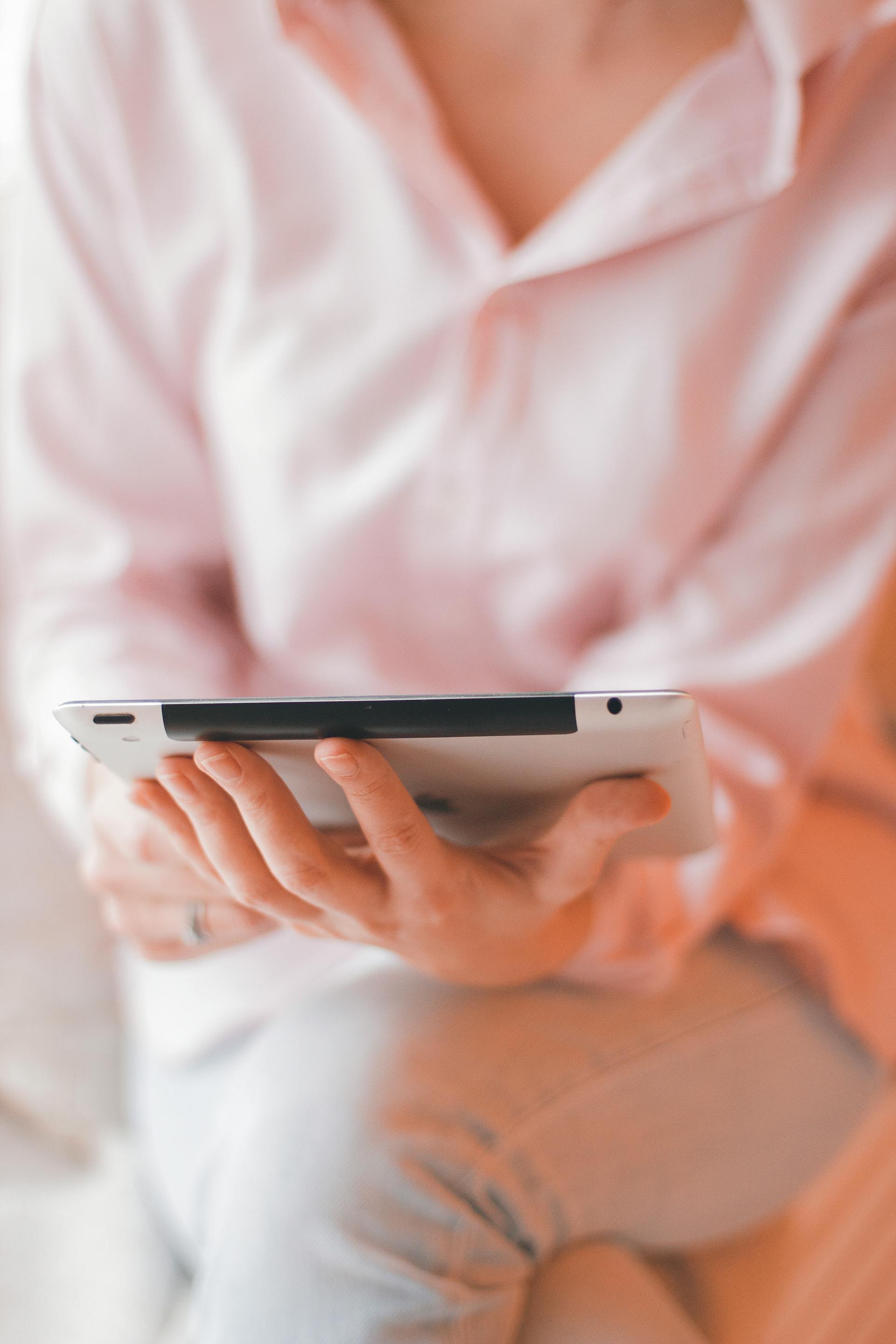 Close-up of a woman holding a tablet | Source: Pexels