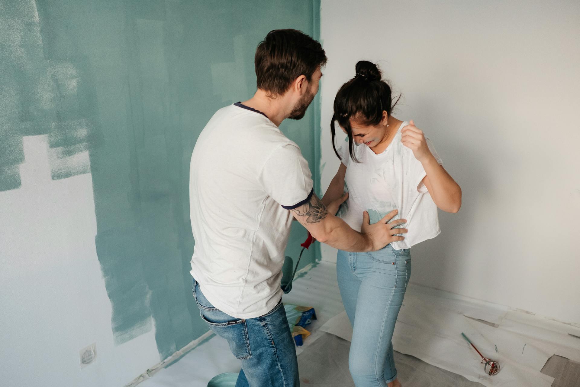 A couple playfully doing home improvements | Source: Pexels