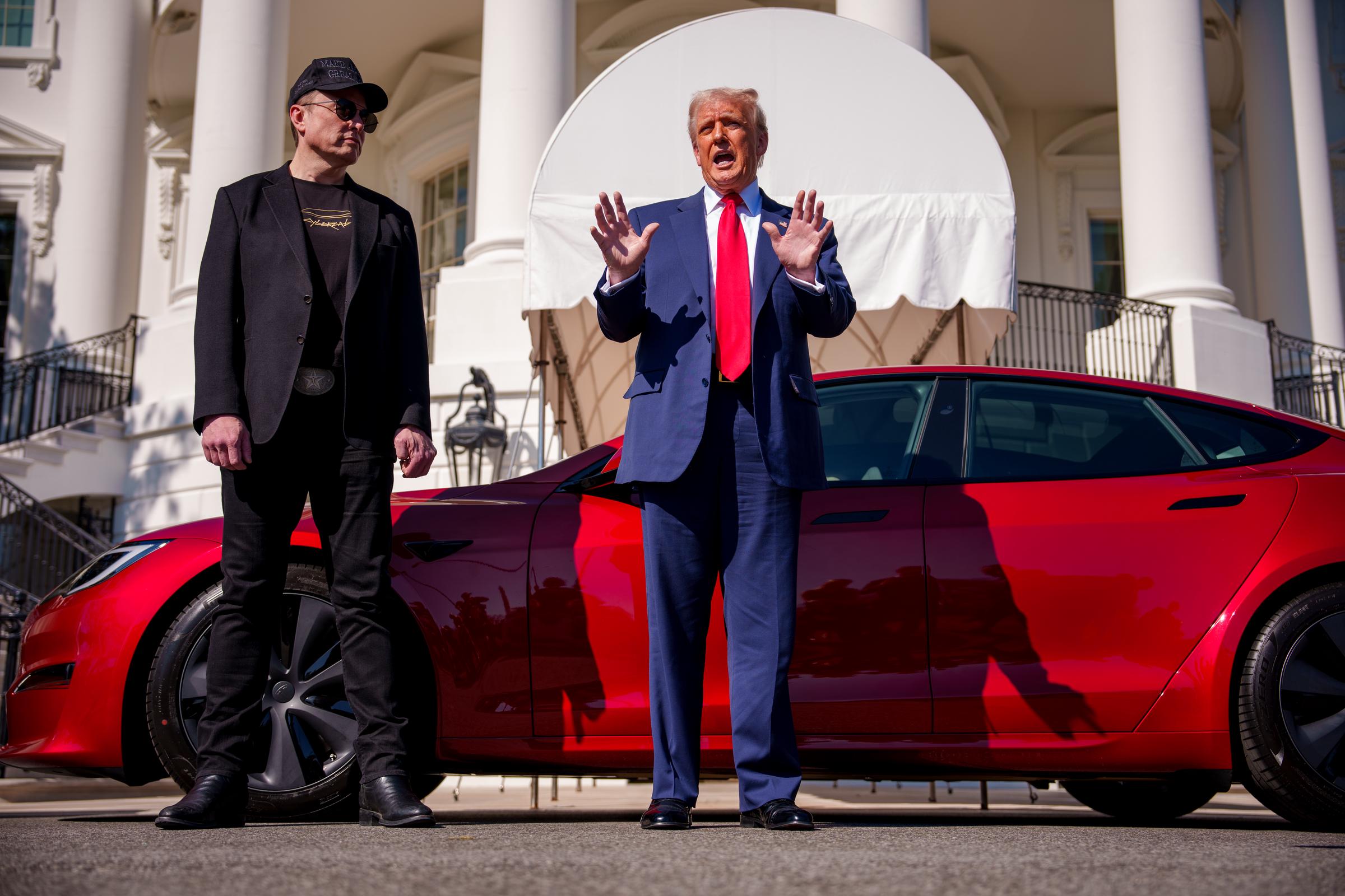 President Donald Trump, accompanied by White House Senior Advisor, Tesla and SpaceX CEO Elon Musk, speaks next to a Tesla Model S on the South Lawn of the White House on March 11, 2025, in Washington, D.C. | Source: Getty Images