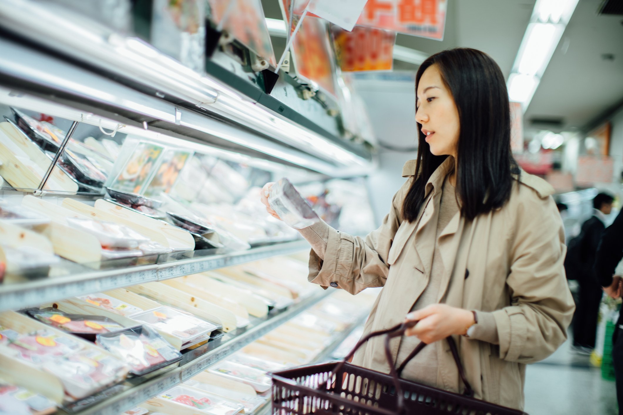 Lebensmitteleinkauf der jungen asiatischen Frau und Auswahl des frischen Geflügels im Supermarkt | Quelle: Getty Images