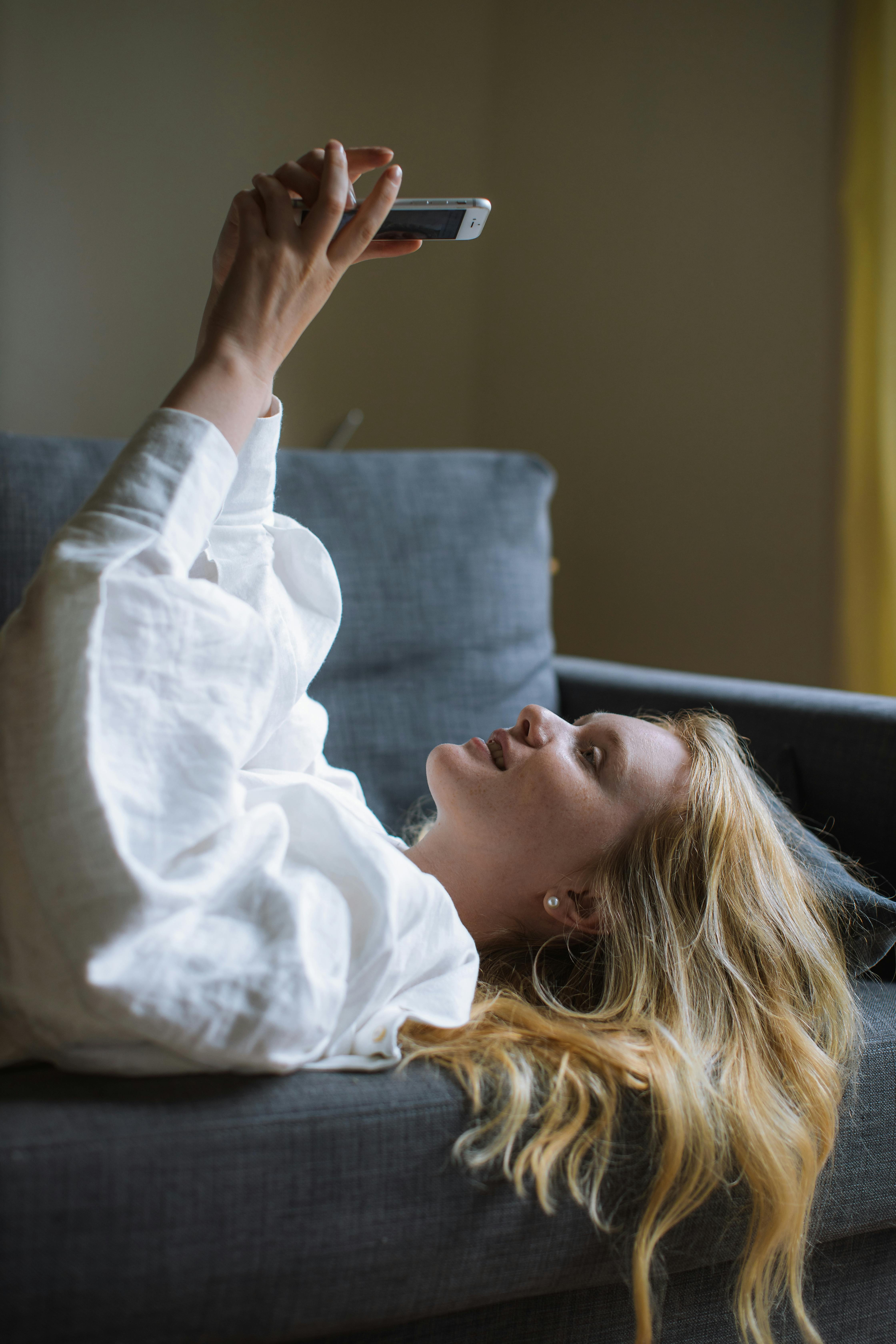 A happy woman using her phone | Source: Pexels