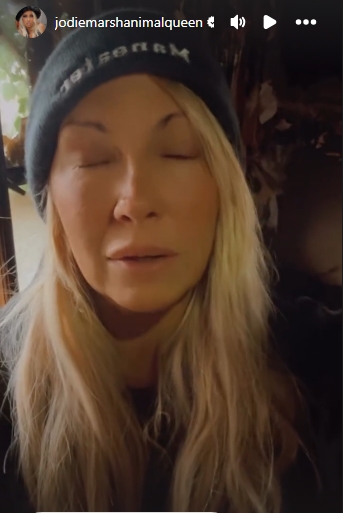 With her eyes closed, Marsh paused to collect herself while describing the emotional weight of trying to continue caring for her animals amid the devastation. | Source: Instagram/jodiemarshanimalqueen