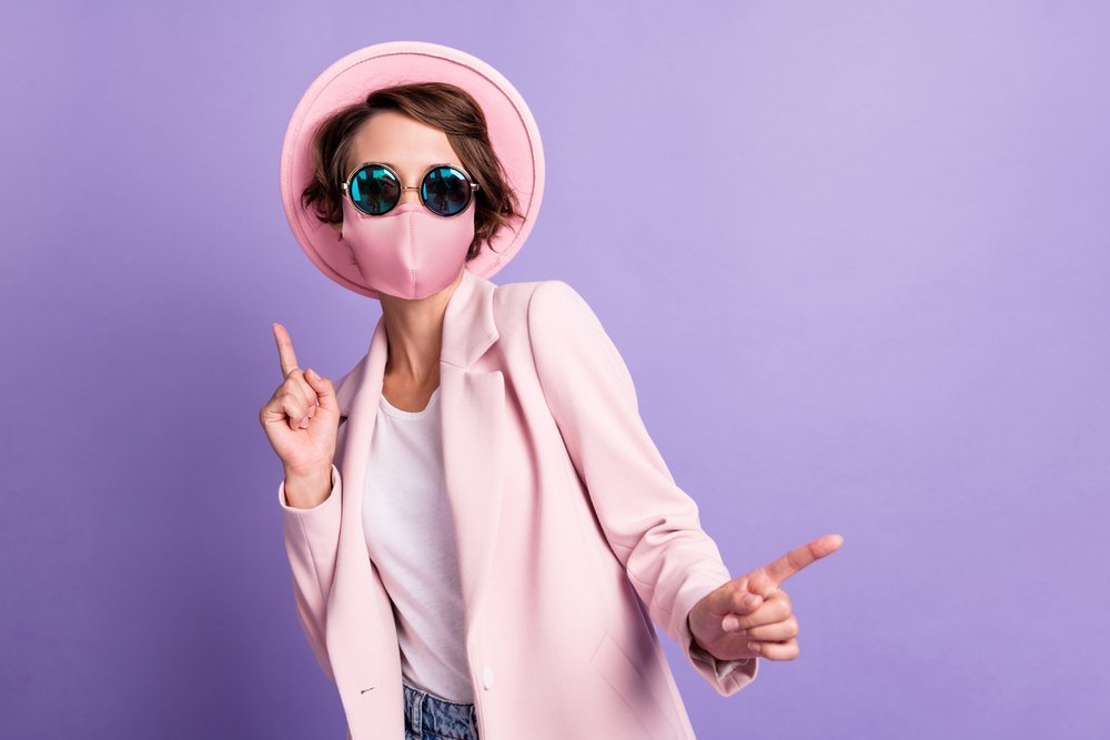 Mujer bailando usando mascarilla y gafas oscuras. | Foto: Shutterstock
