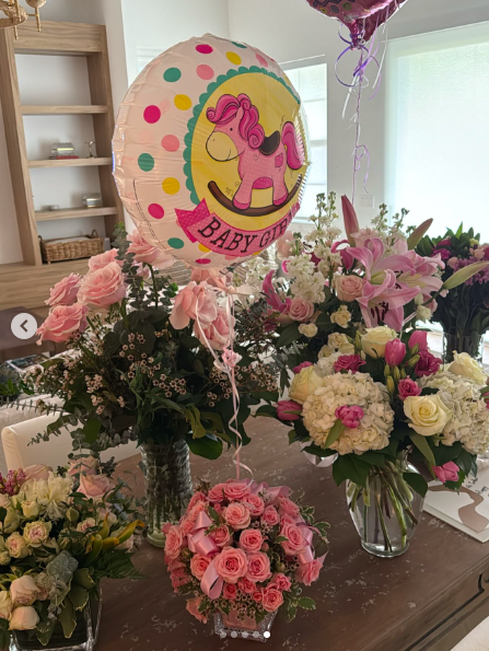 A table filled with flowers and a balloon celebrating the arrival of Claudia Lemieux Bishop's baby girl. | Source: Instagram/claudialemieuxbishop