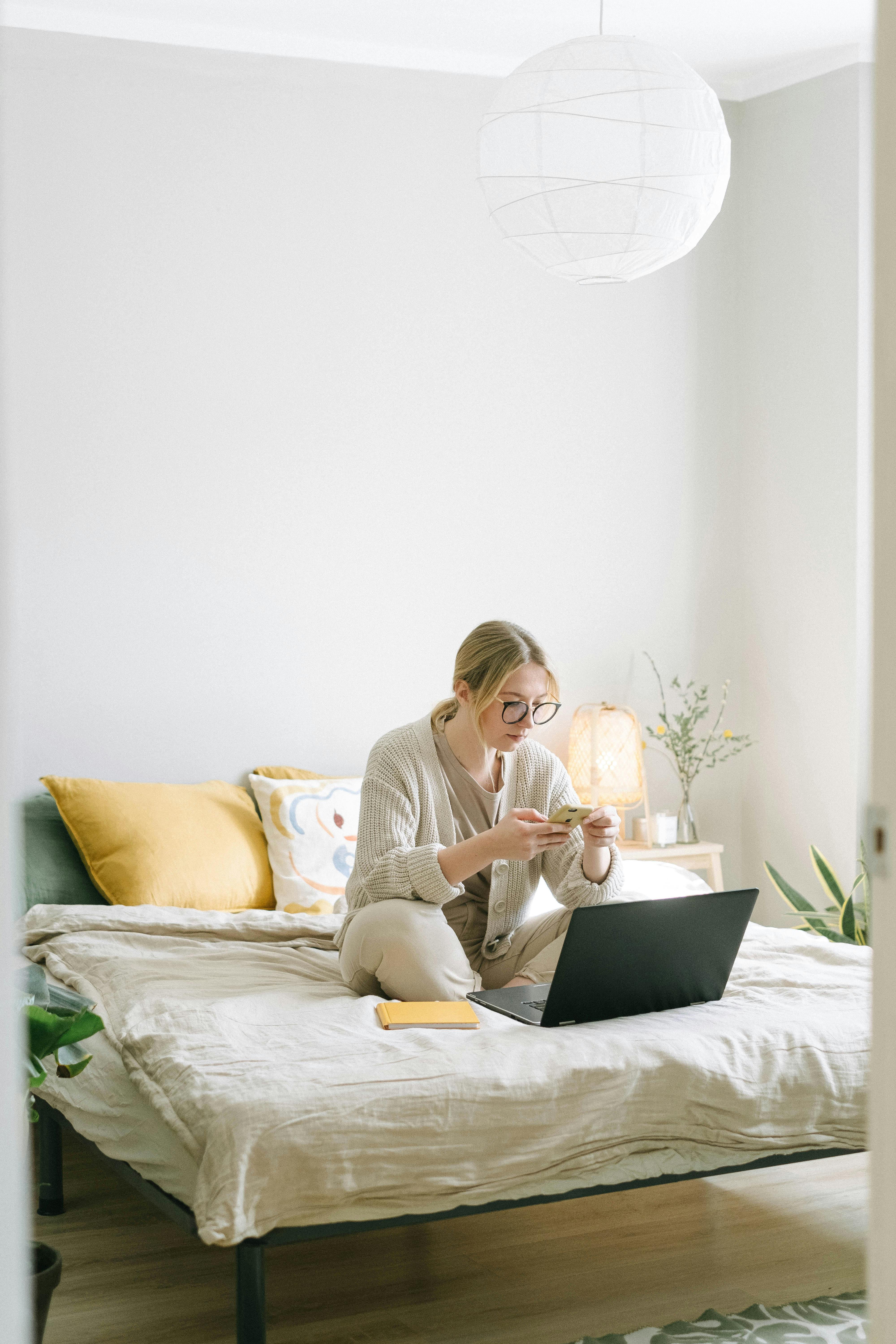 A woman texting on her phone in her bedroom | Source: Pexels